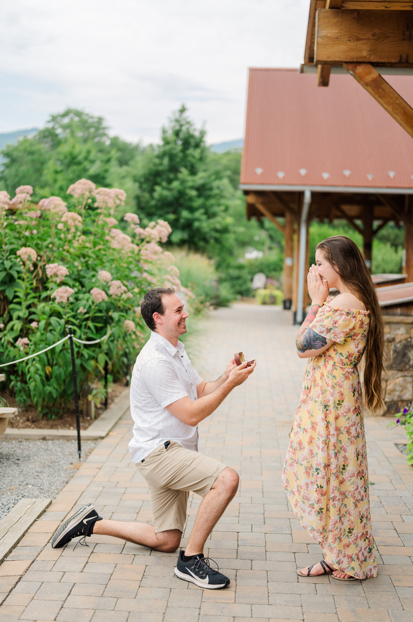 Man is down on one knee proposing to a woman at Devil's Backbone Brewery in Virginia