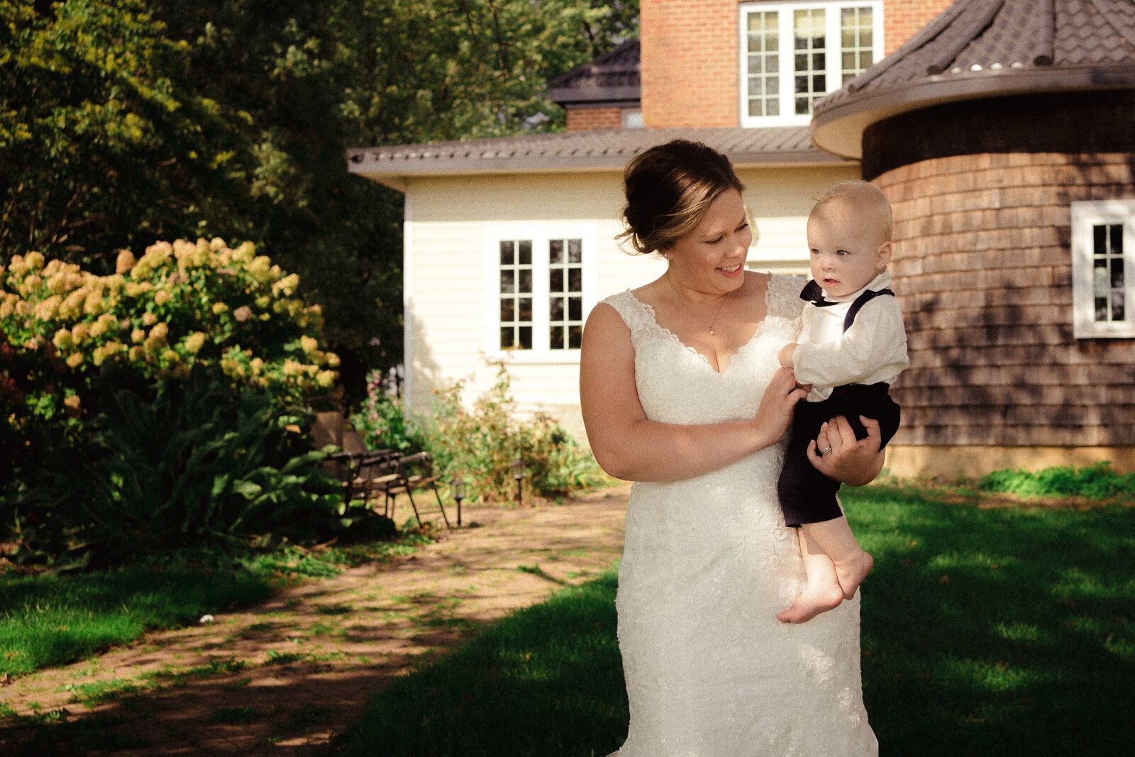 photojournalistic image of bride holding her son, the ring bearer.