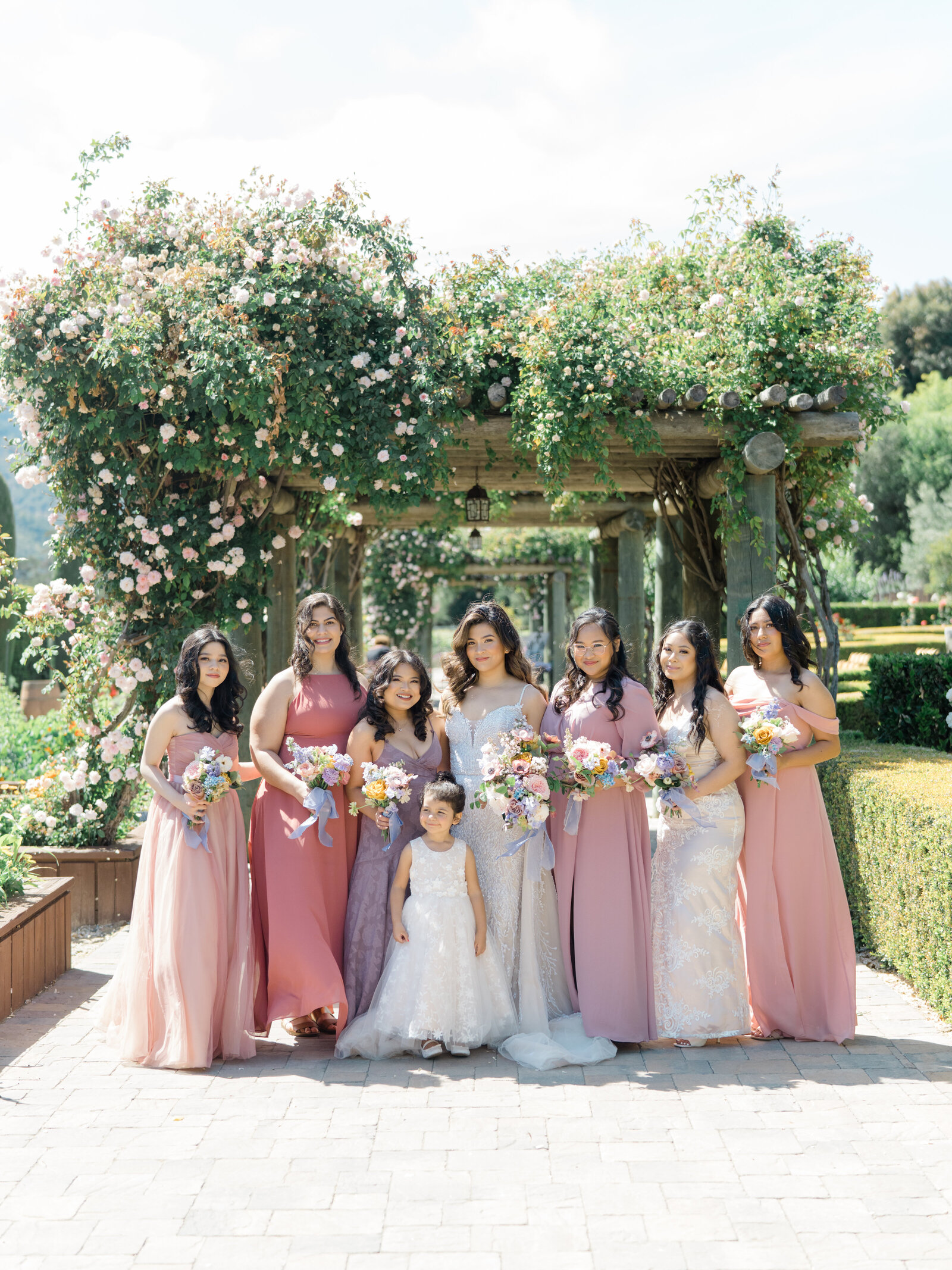 bride with her bridesmaids and flower girl in pink gowns