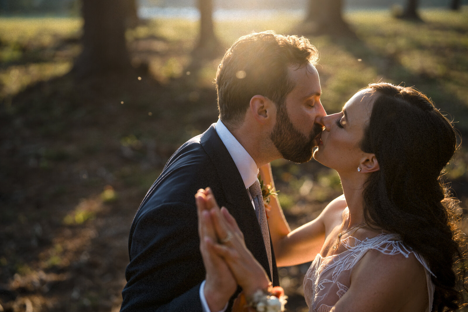 bride and groom kiss during romantic sunset in Massachusetts