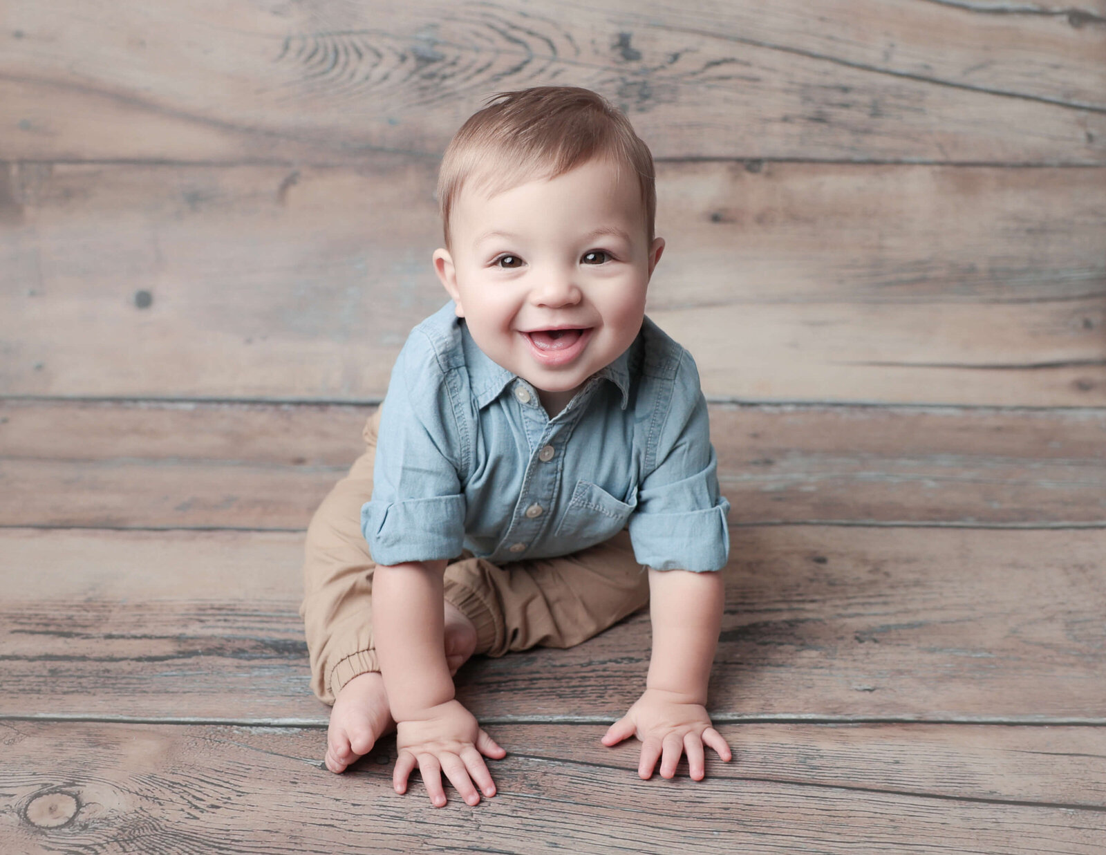 Happy one year old boy posed at our studio in Rochester, NY.