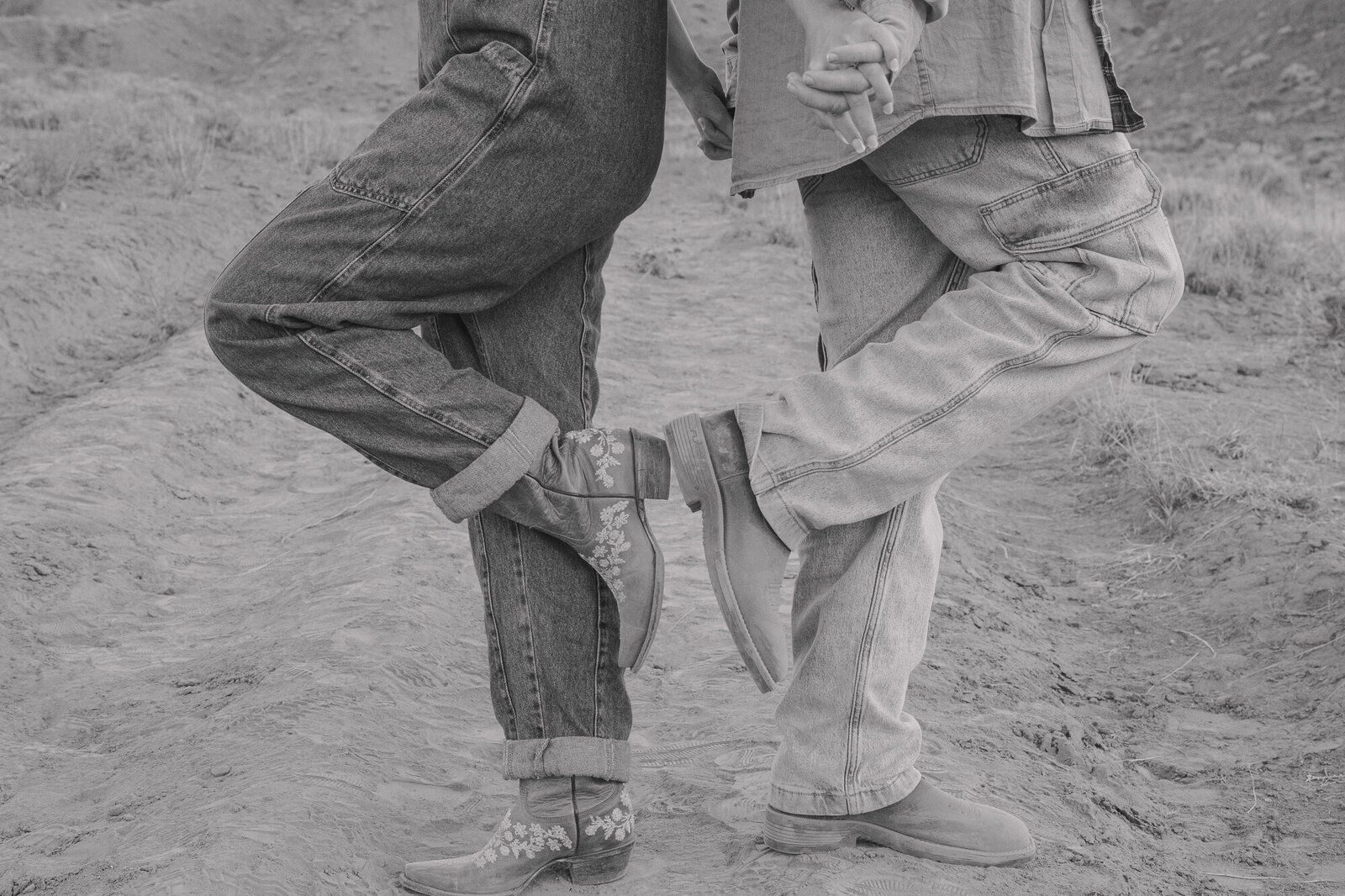 couple with cowboy and cowgirl boots touching each other