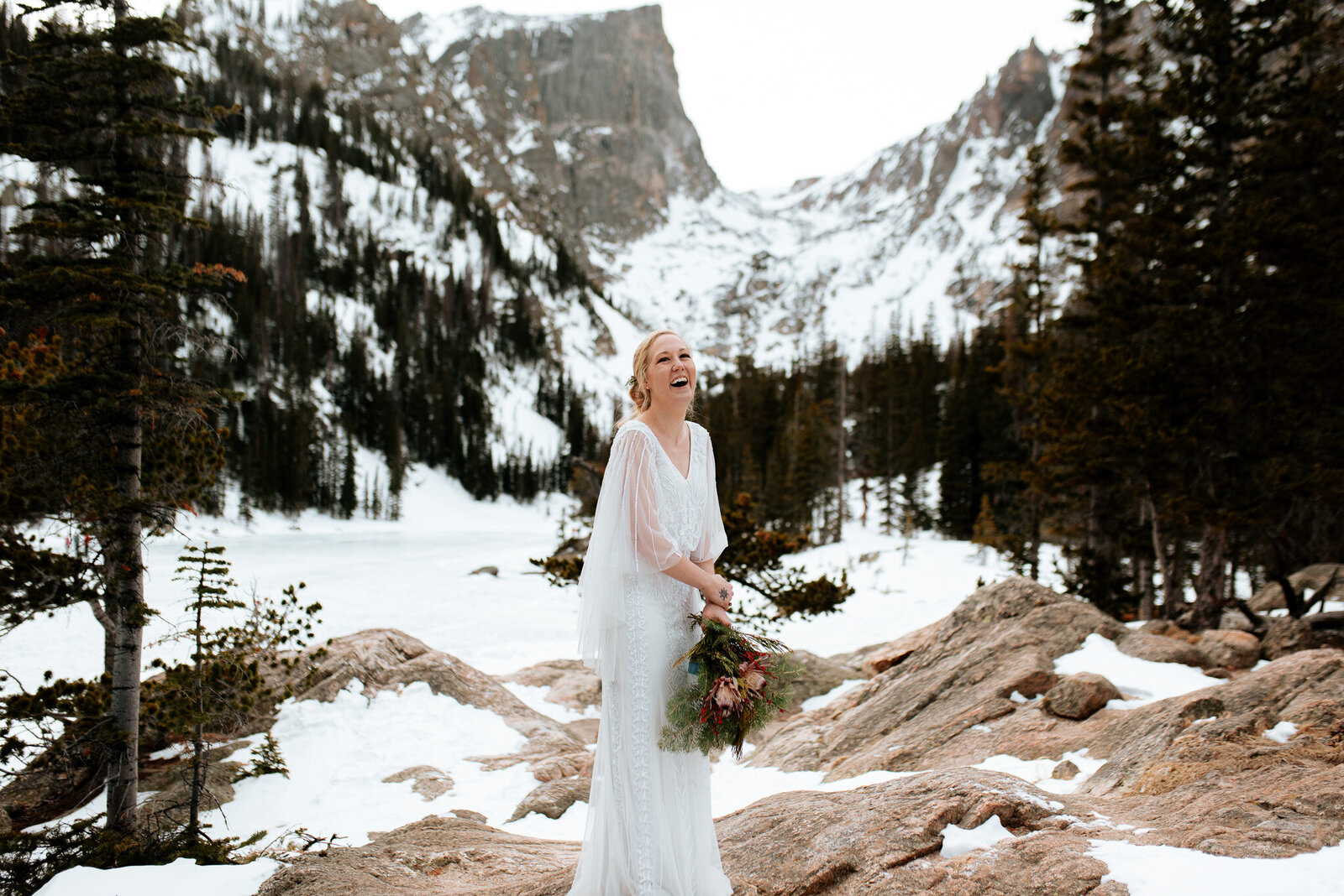 Bride in the snow at her winter wedding in Rocky Mountain National Park at Hallet's peak in Colorado.