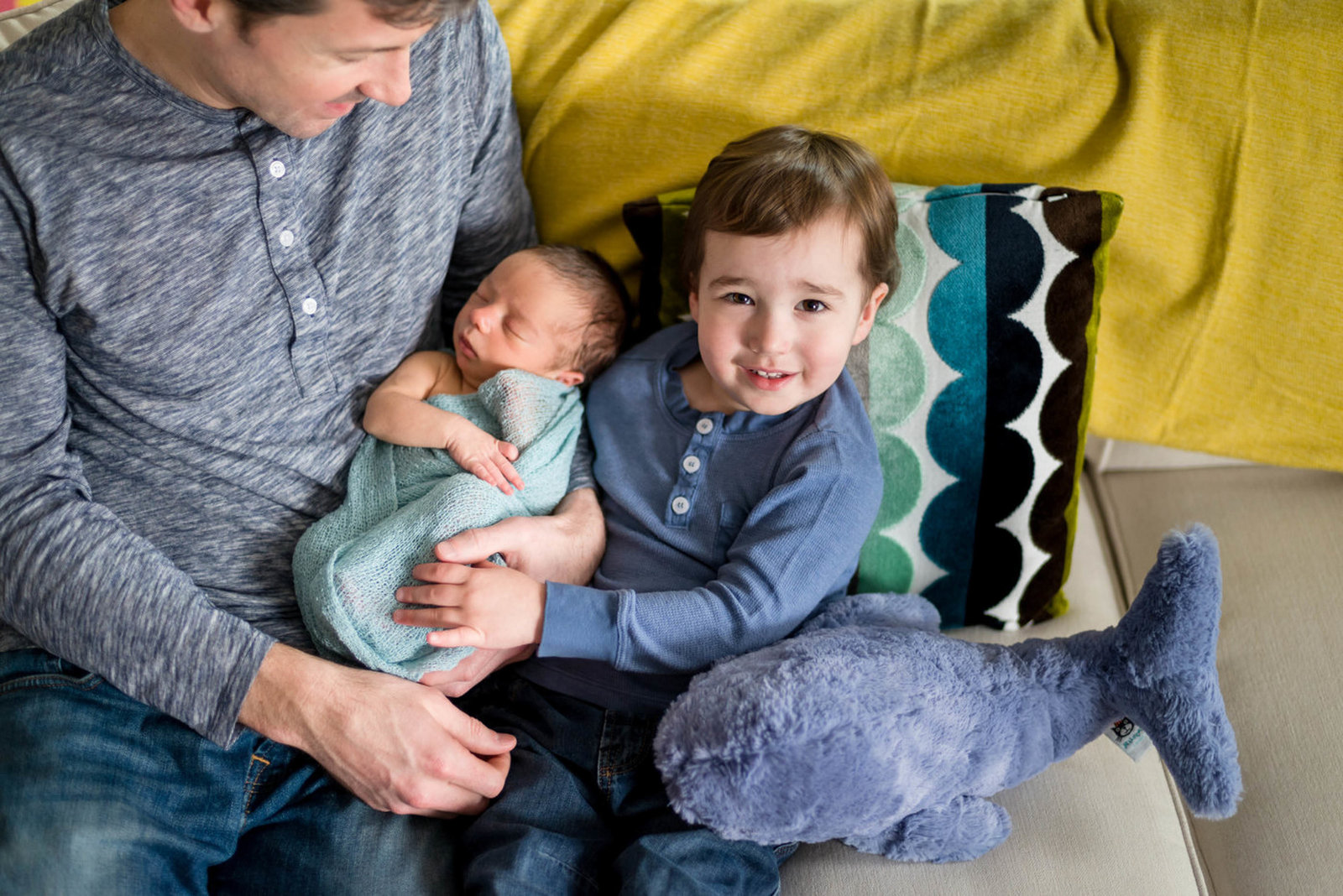Father and big brother holding newborn at home lifestyle session Boston