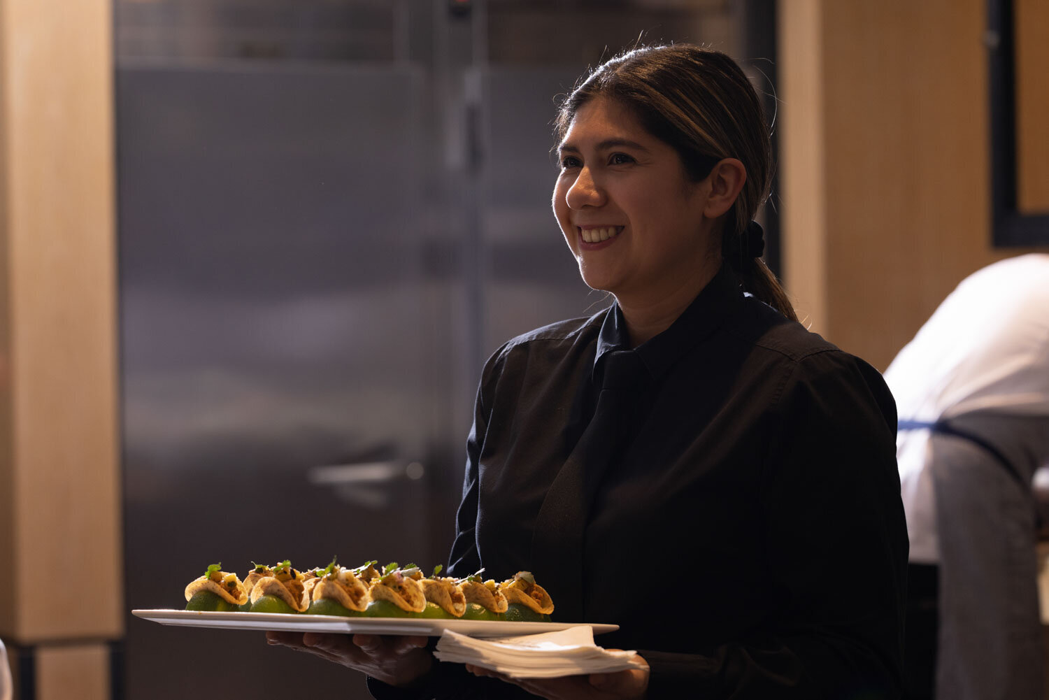 A woman is holding a plate of food and smiling