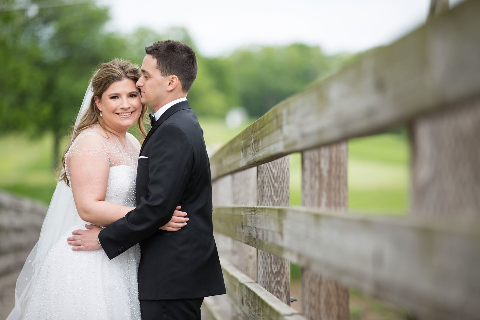 bride and groom standing by the fence at Engineers Country Club