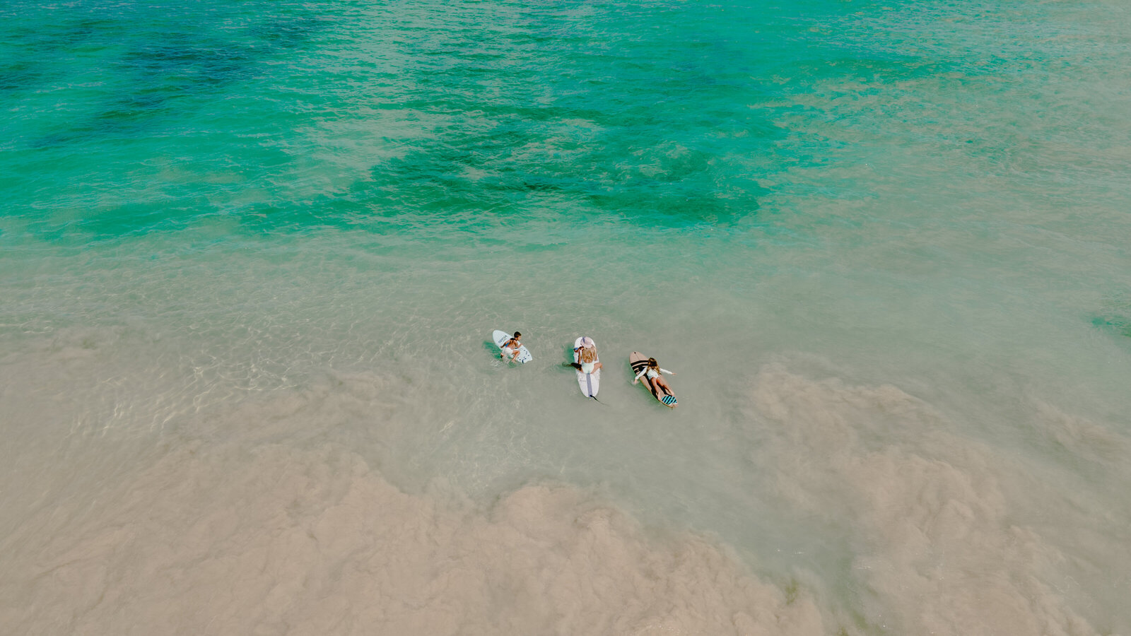 Mersadi Olson, Hawaiian photographer goes for a swim on their surfboards in the Oahu ocean with her kids on