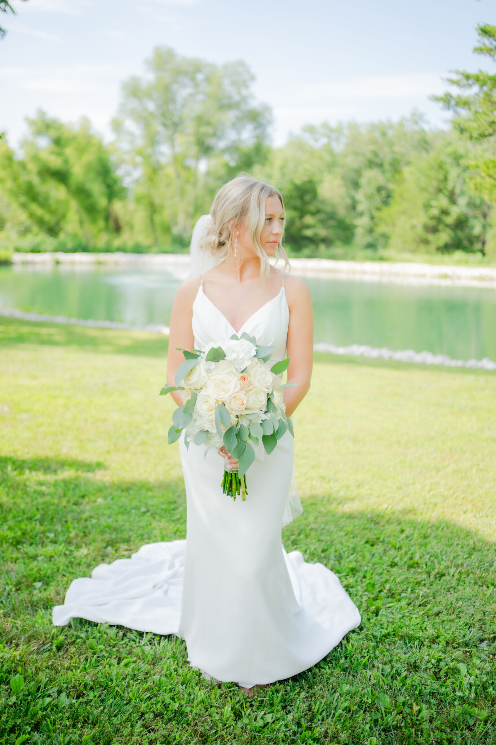 Blonde hair bride holding a bouquet facing straight and looking to the right