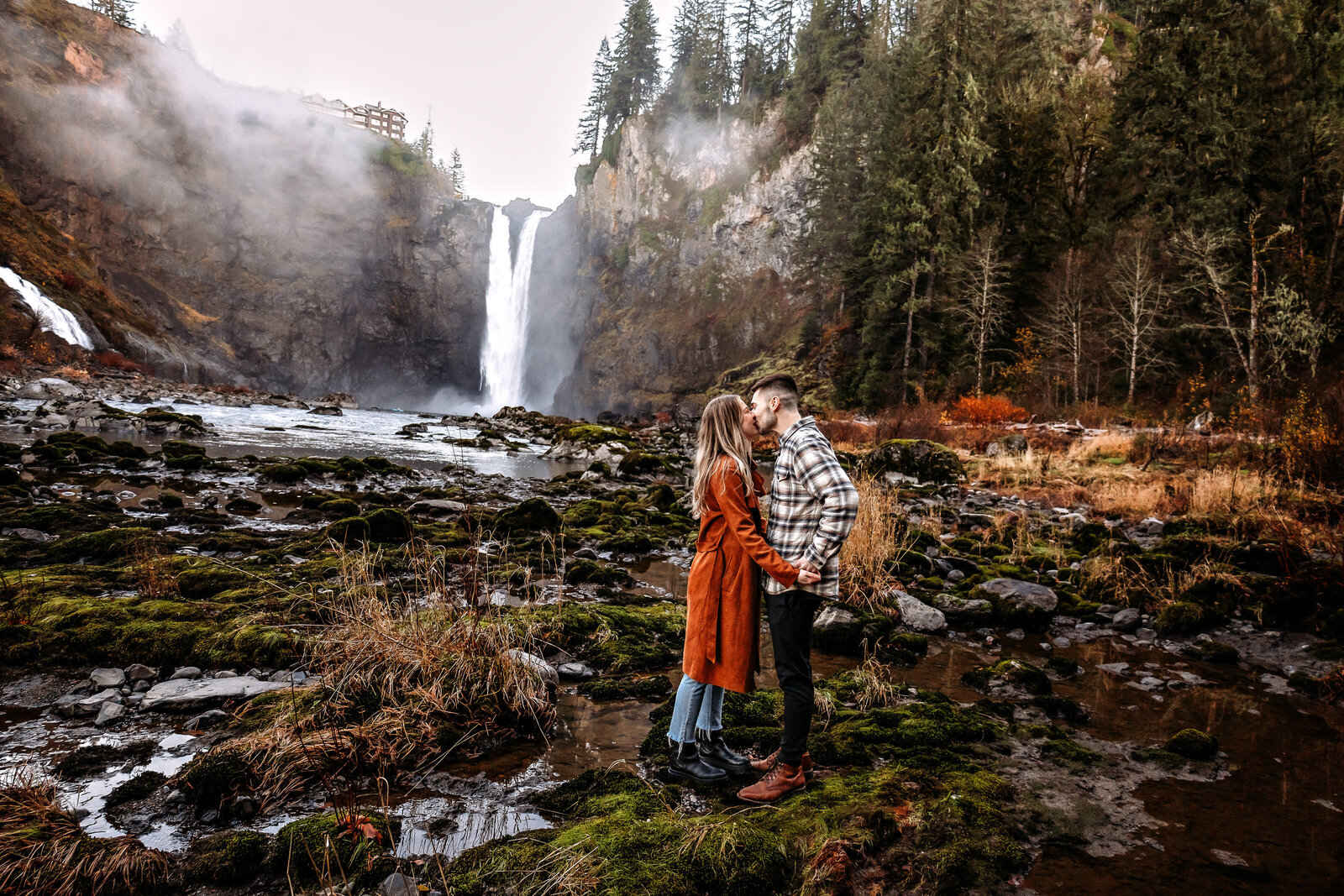 Celebrate love in its most natural setting with this rustic and romantic photo of a couple at a PNW waterfall, where nature crafts the perfect backdrop for timeless moments.