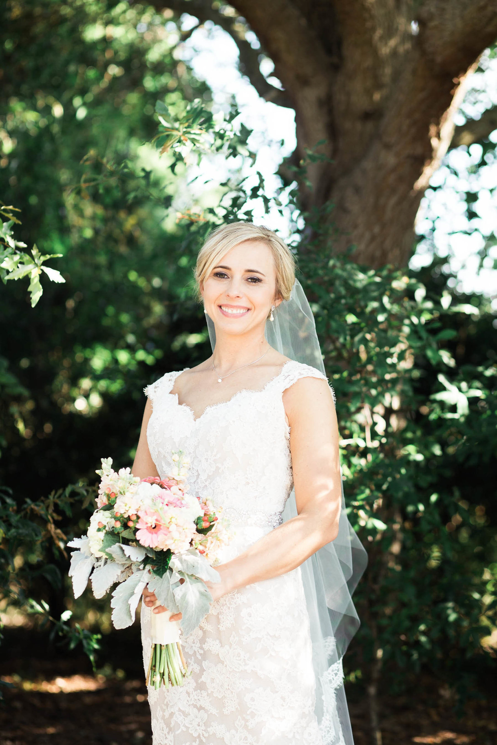 Bride stands among the trees, Alhambra Hall, Mt Pleasant, South Carolina