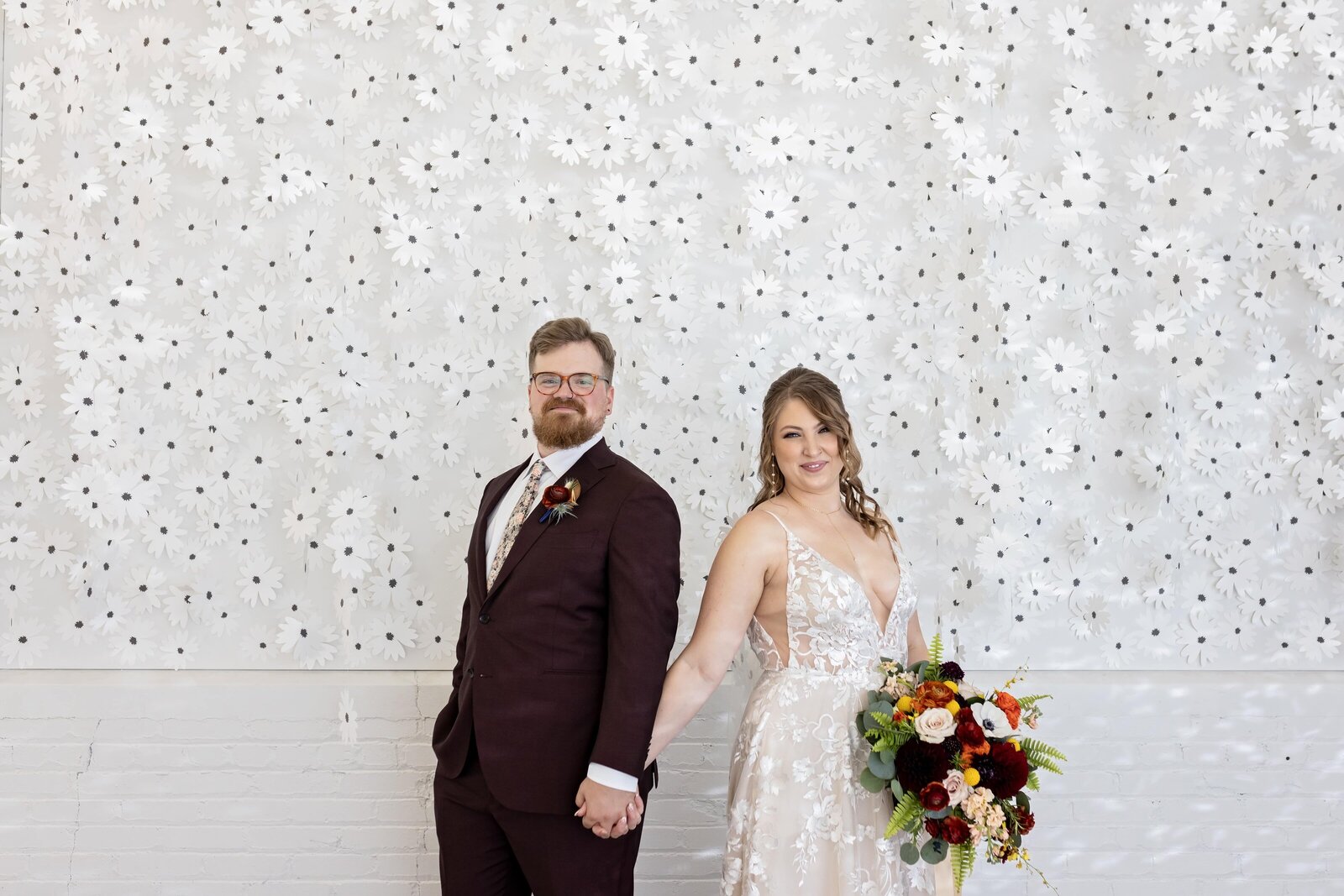 bride-groom-portrait-hanging-flower-wall-urban-daisy