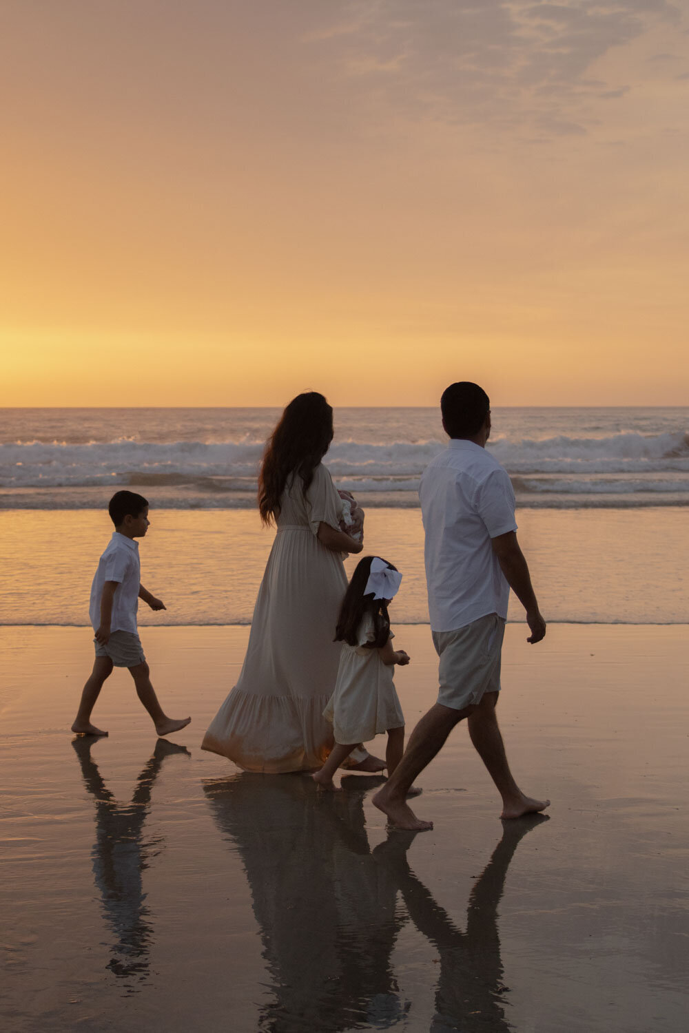 Family walking along the beach at sunset