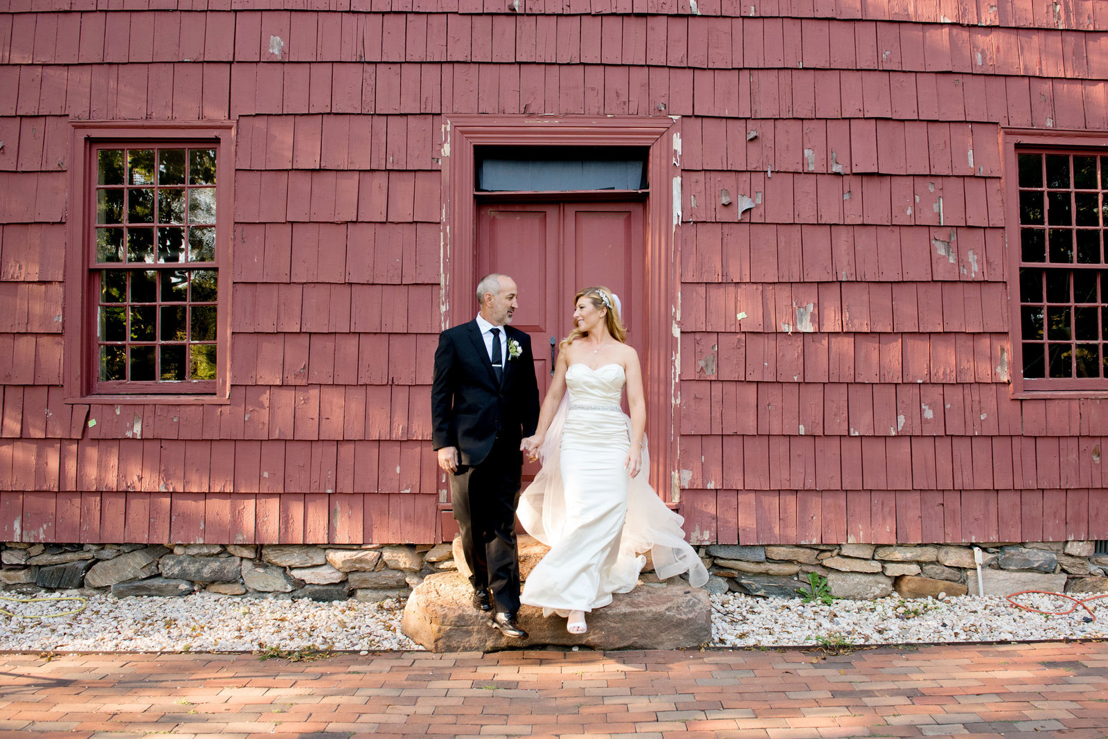 bride and groom standing outside the barn at George Weir Barn