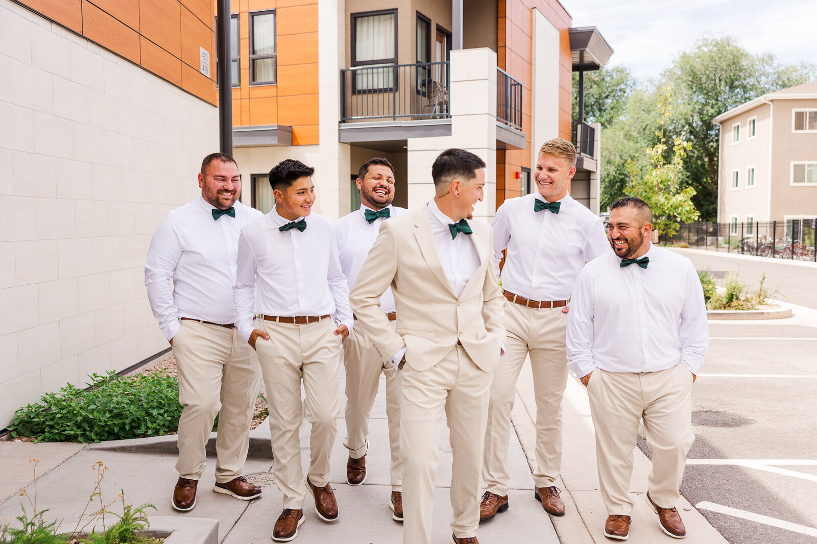 Group of groomsmen walking in white suits before the wedding starts in Moab utah