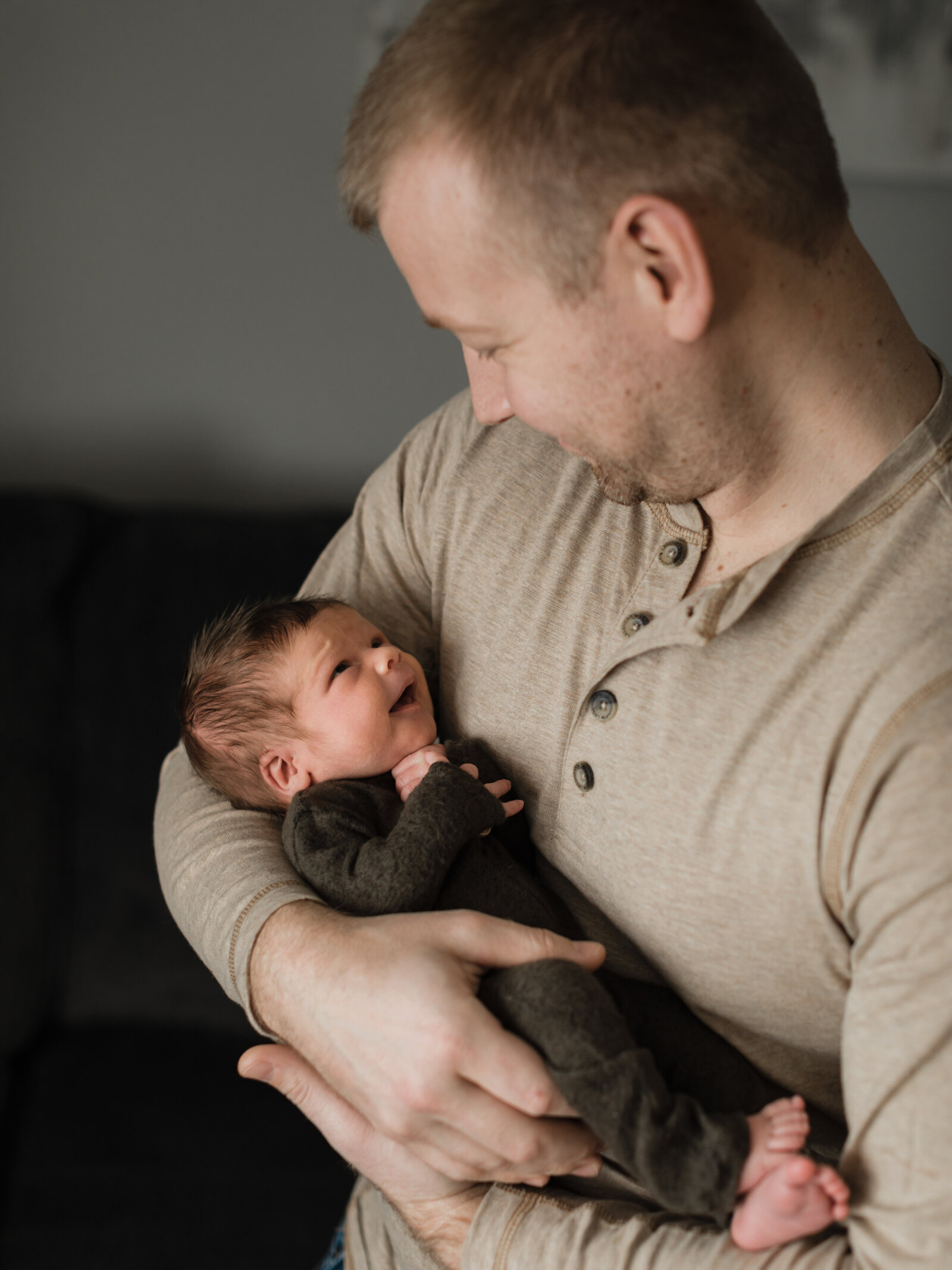 dad holding newborn baby boy for in home lifestyle photoshoot