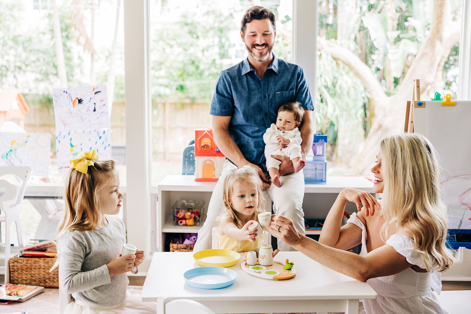 Photographer in st. pete captures family happily playing with a new baby at home.