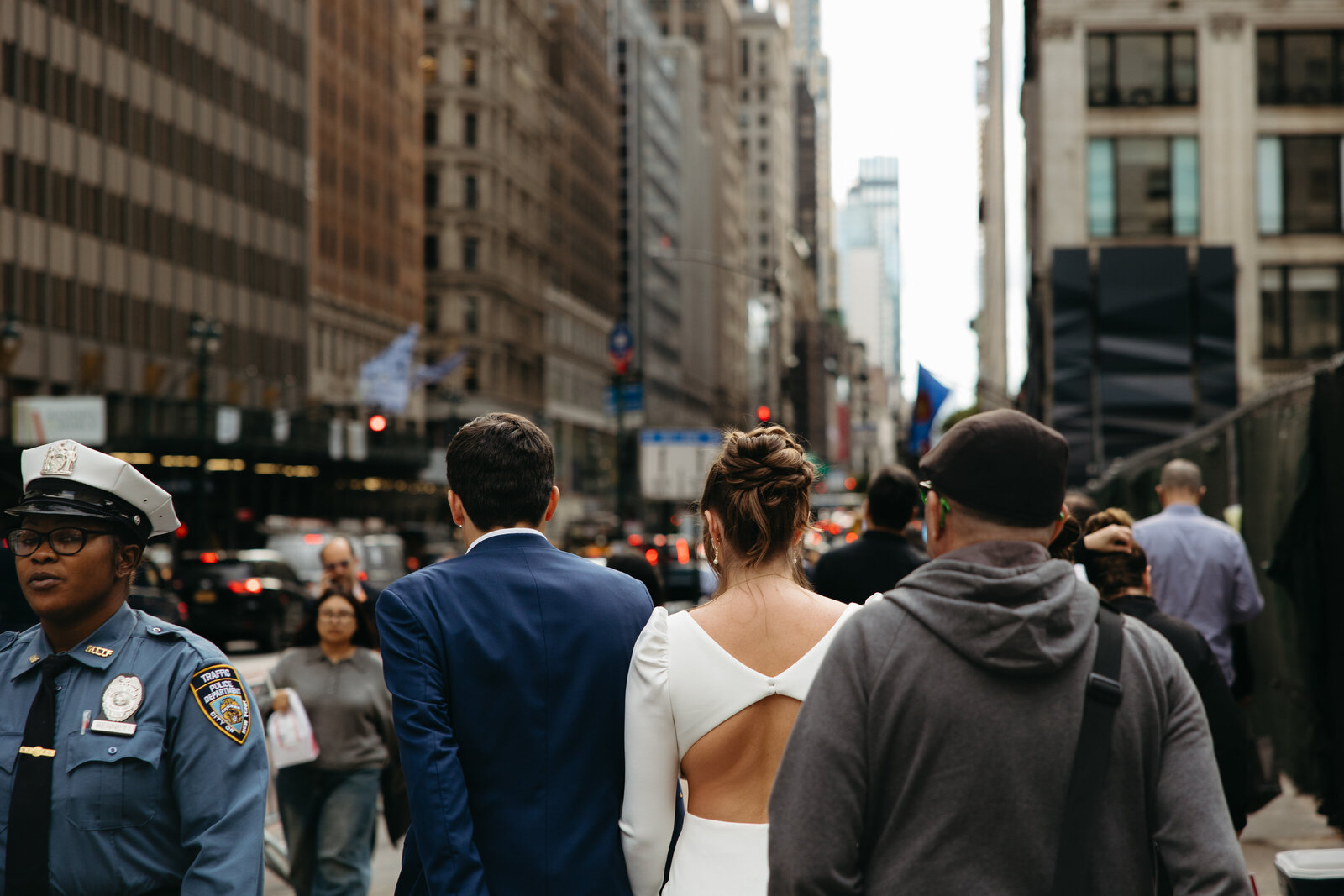 Bride and Groom walking along New York sidewalk in a crowd