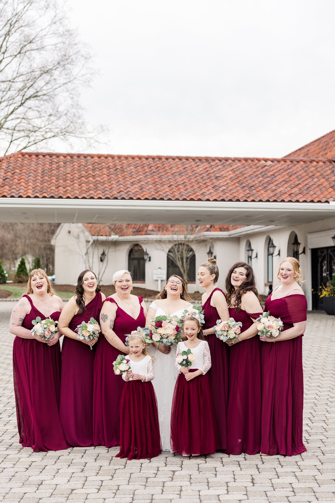 Bride surrounded by her bridesmaids and flower girls, all smiling together at Perona Farms weddin