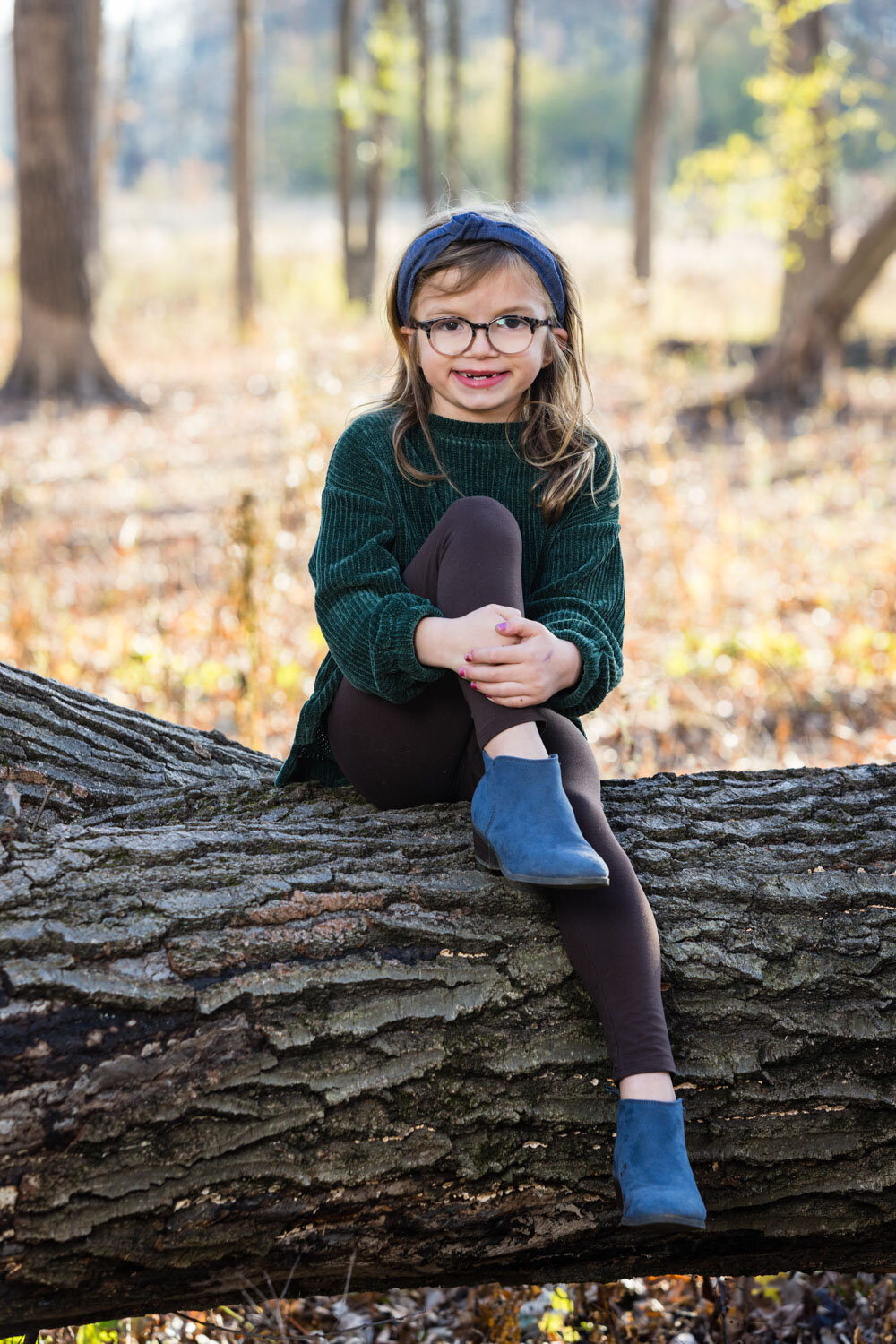 baby girl in green sweater sitting on a lodge