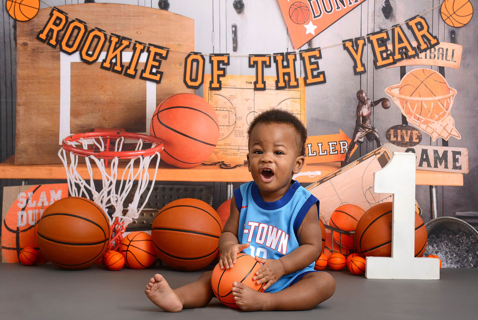 boy wears a htown jersey at his basketball themed first birthday photoshoot