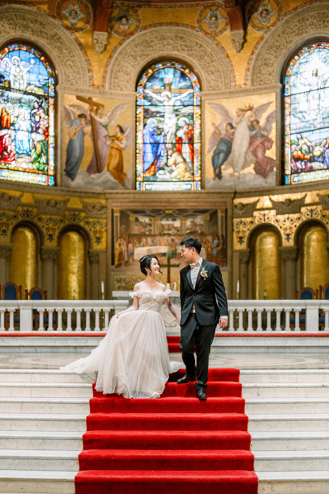 The bride and groom stand together at the altar of the iconic Stanford Memorial Church, highlighting the elegance of their California wedding.