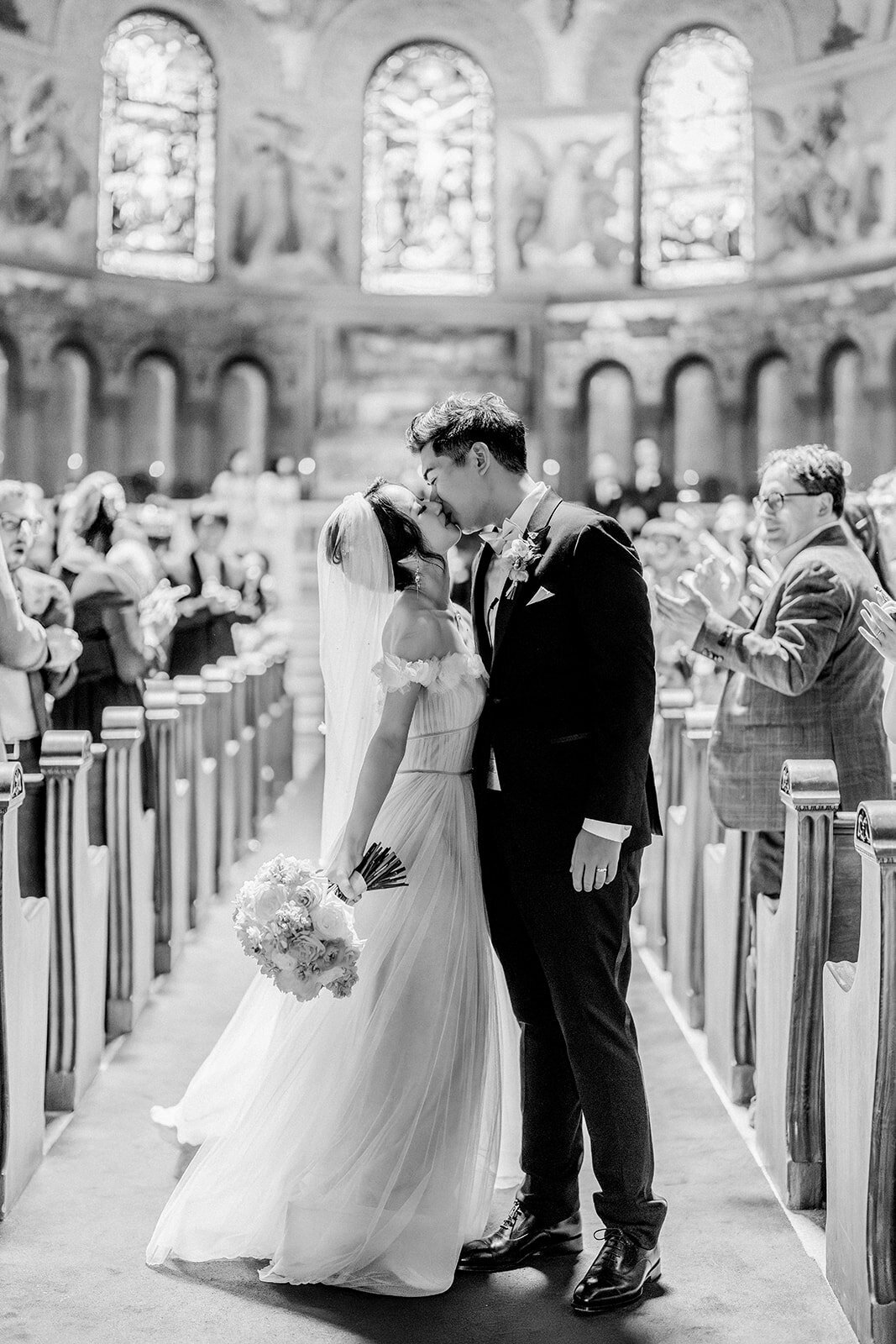 The bride and groom share a heartfelt kiss at the Stanford Memorial Church, adding a touch of romance to their California wedding.