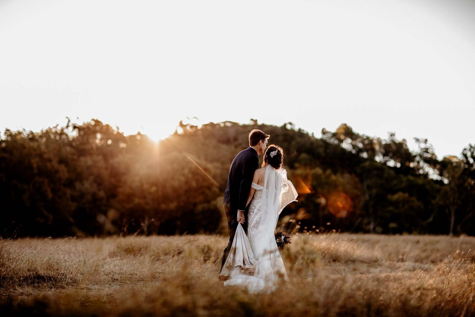 sun setting behind newlyweds