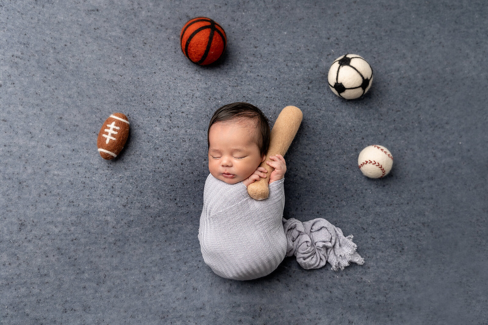 baby boy posed with sports balls by Newborn Photography Bucks County PA