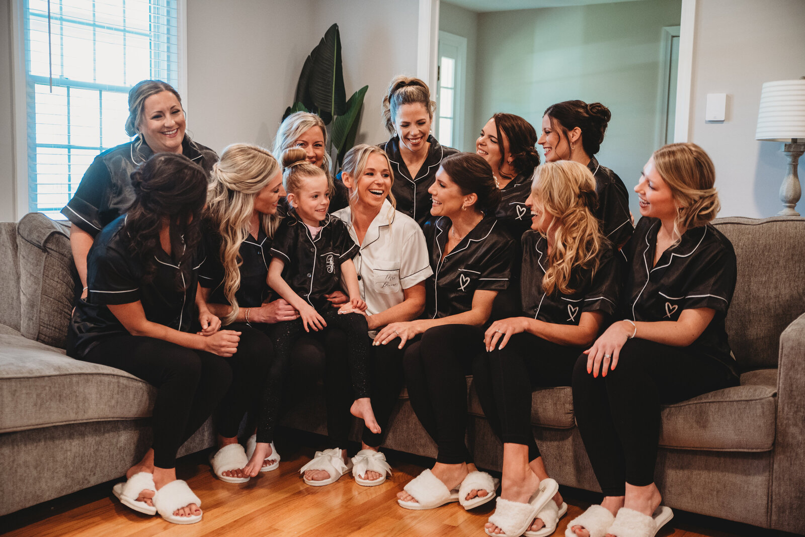 Candid moment of a bride and her bridesmaids sharing laughter and excitement while getting ready in matching satin pajamas. This joyful pre-wedding preparation captures the love, friendship, and anticipation before the big day. Perfect for Connecticut brides looking for wedding inspiration and photography ideas.