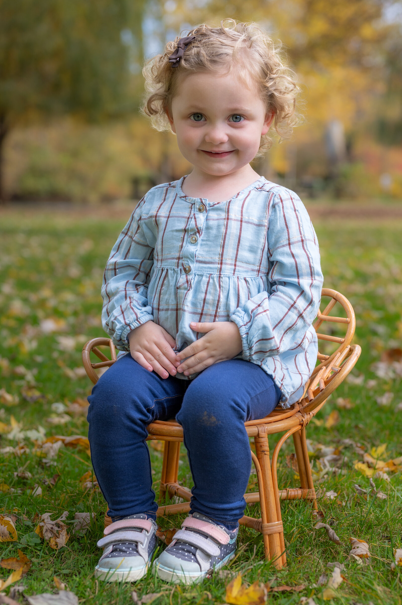 little girl sits in a chair outside for school pictures