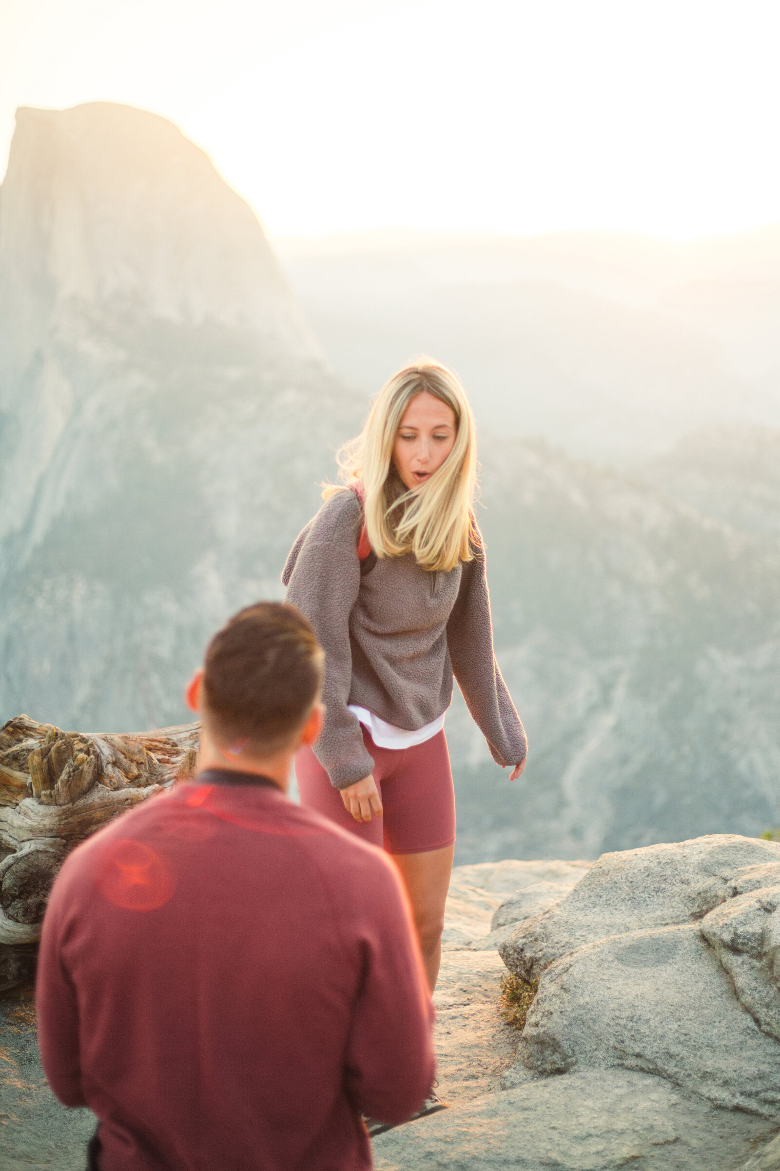 A wedding proposal between two hikers at sunrise in front of Half Dome in Yosemite National Park.