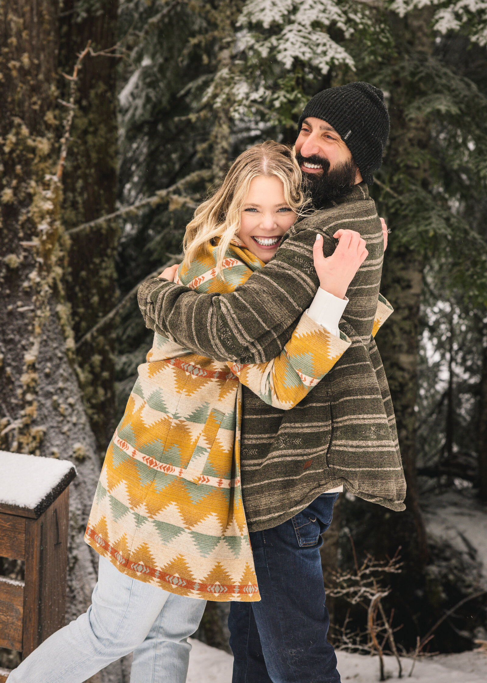 Newly engaged couple hugging in the snow at Mirror Lake Trailhead in Mount Hood, Oregon.