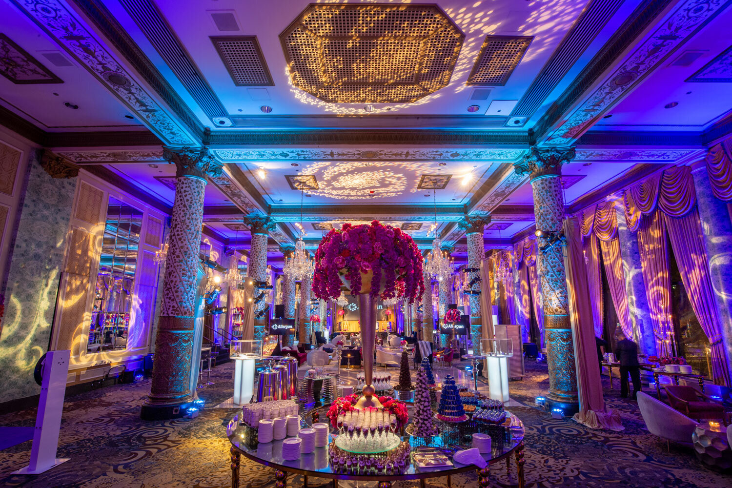 Elegant event lounge setup with chandeliers and vibrant floral decor