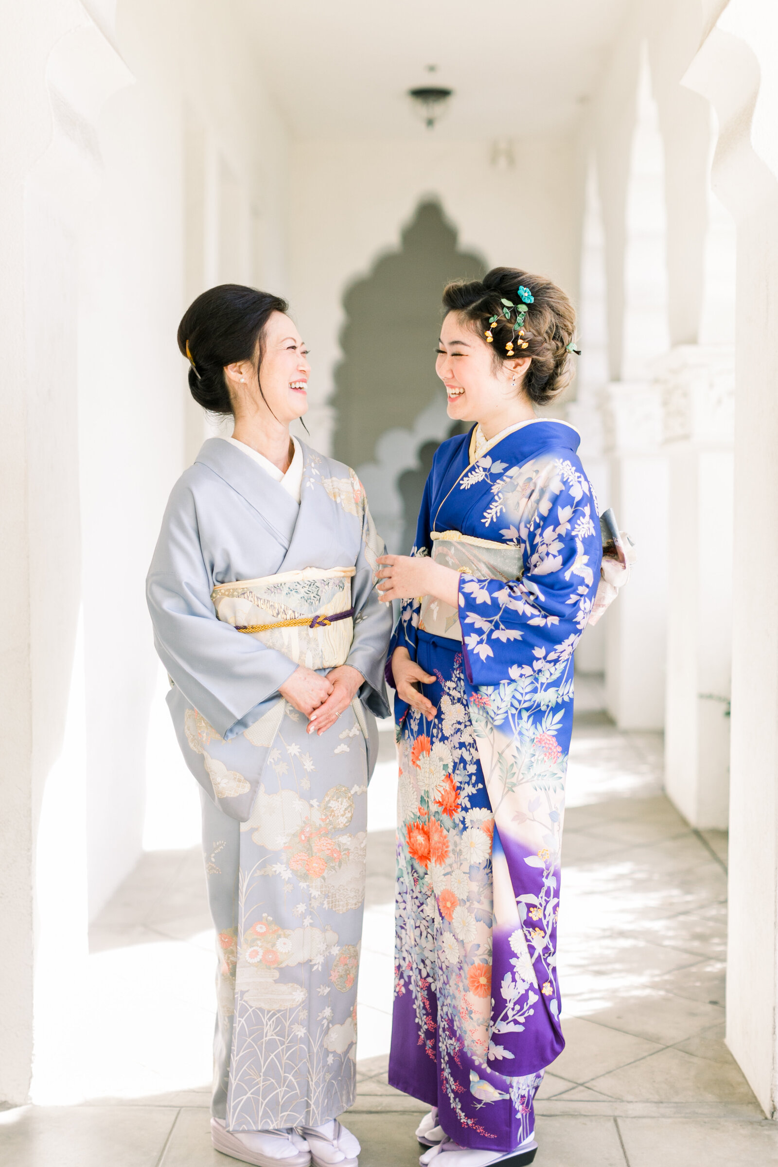Mother and daughter sharing a joyful laugh in elegant kimonos during a Seijinshiki celebration at Brand Park Glendale. Mom & daughter kimono rental in Los Angeles | 成人式を祝う母娘がブランドパーク（グレンデール）で笑顔を交わす、親子で着物レンタル