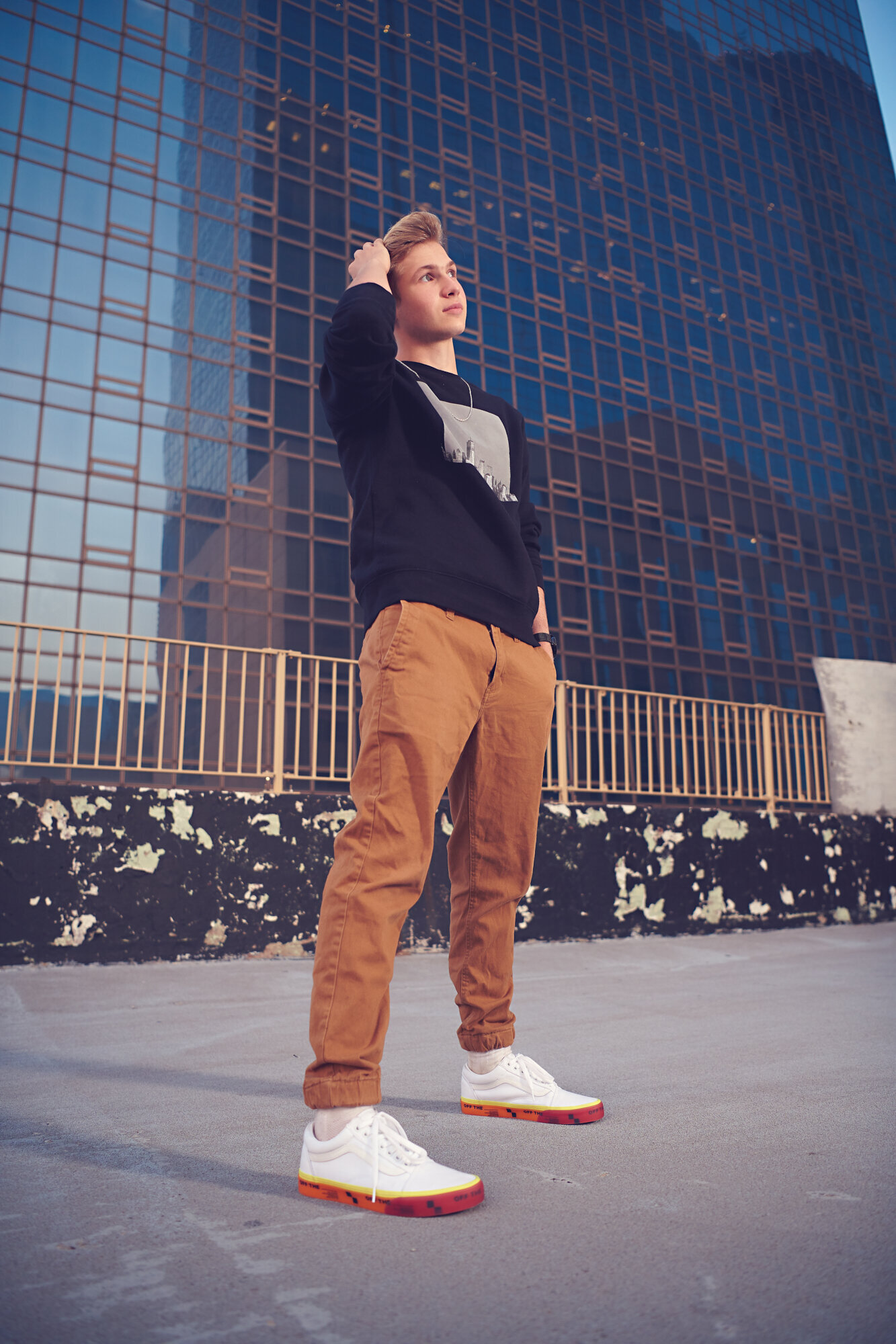 Boy standing on rooftop for senior pictures fashion