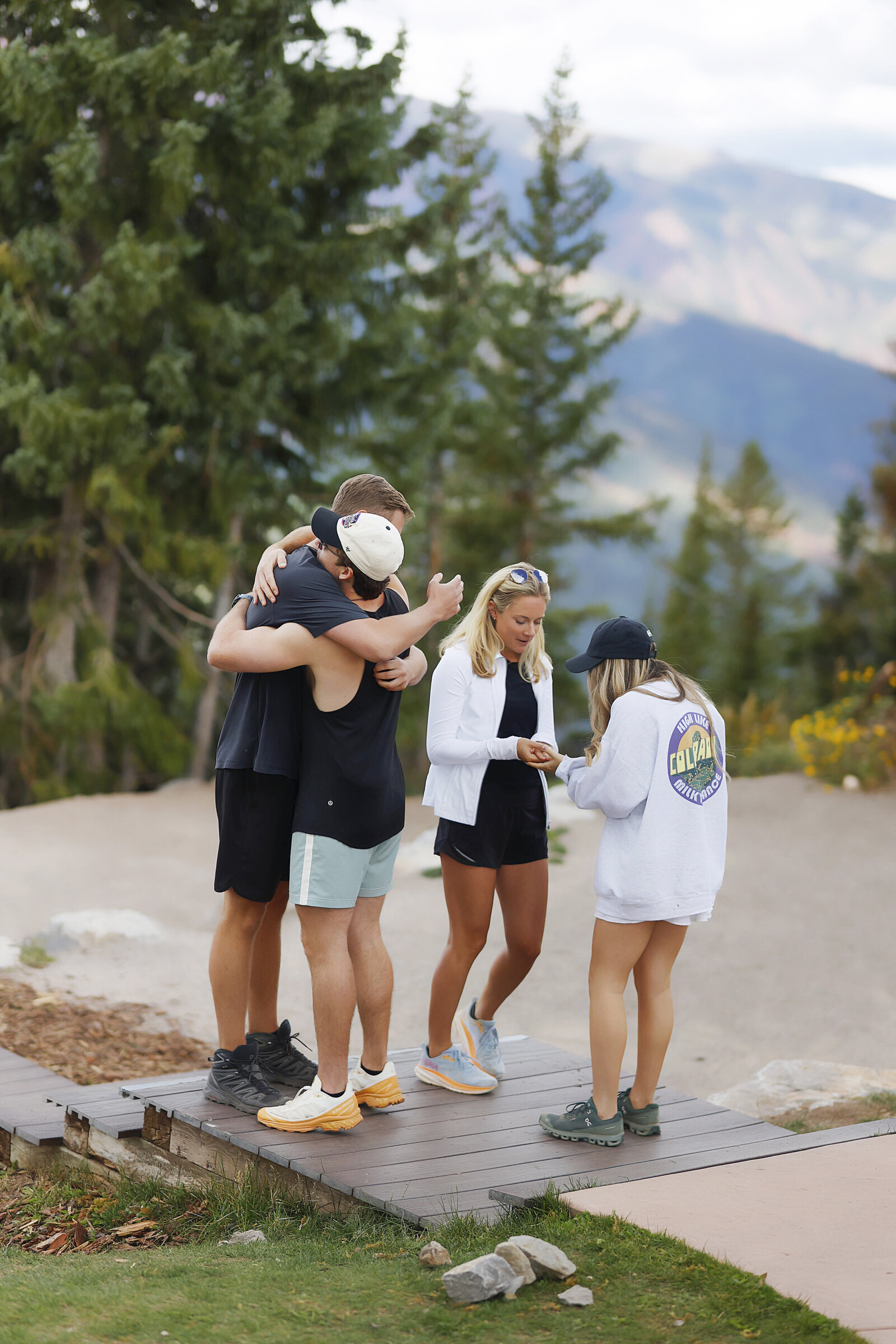 A couple of friends hug after watching the surprise proposal happen on Aspen Mountain in Aspen, Colorado.