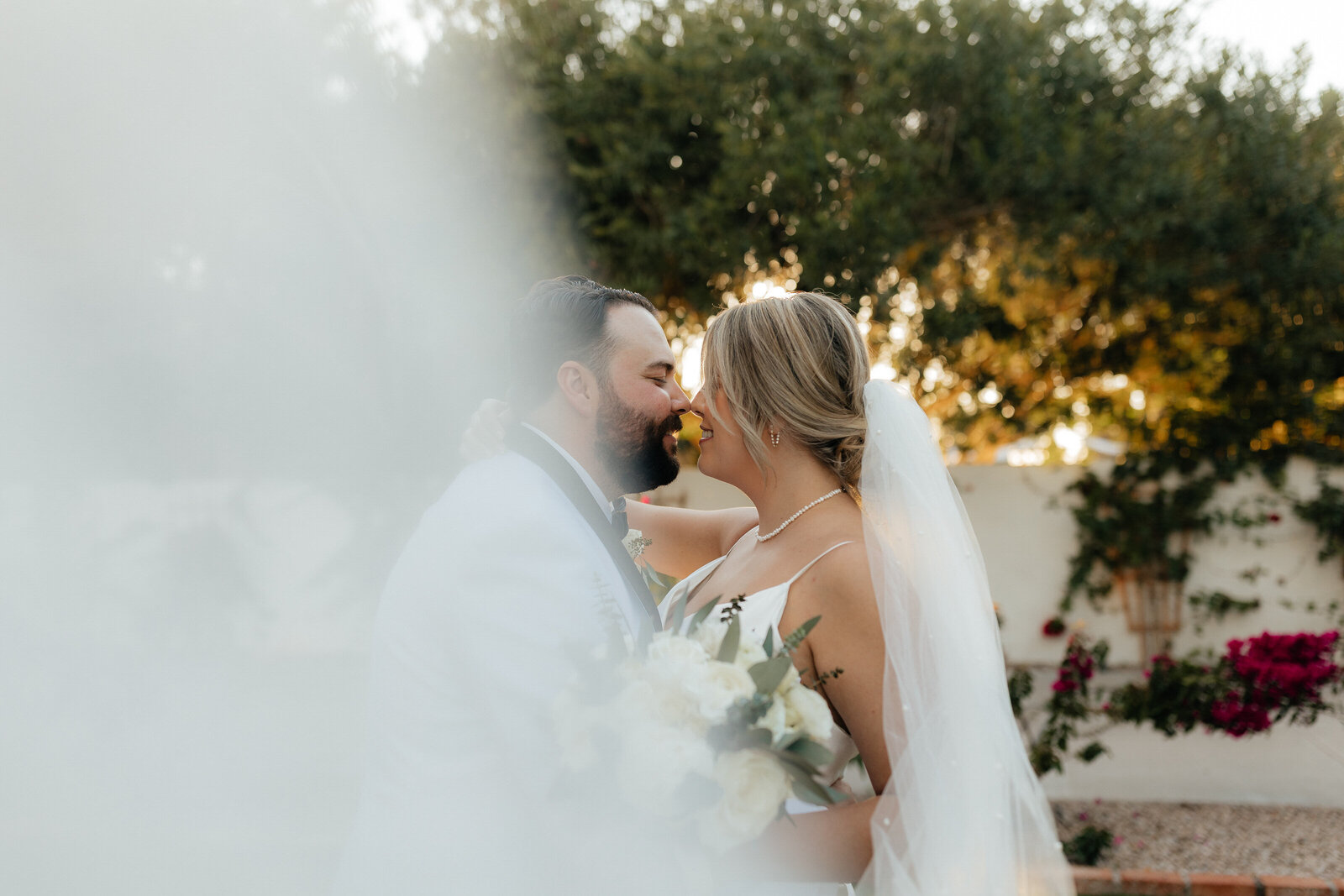 Bride and groom kiss beyond the veil on their wedding day in Chandler AZ
