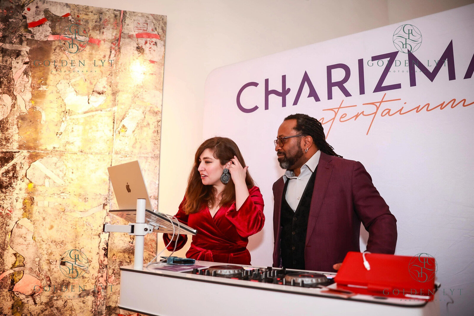 Two DJs at a booth with Charizma Entertainment sign