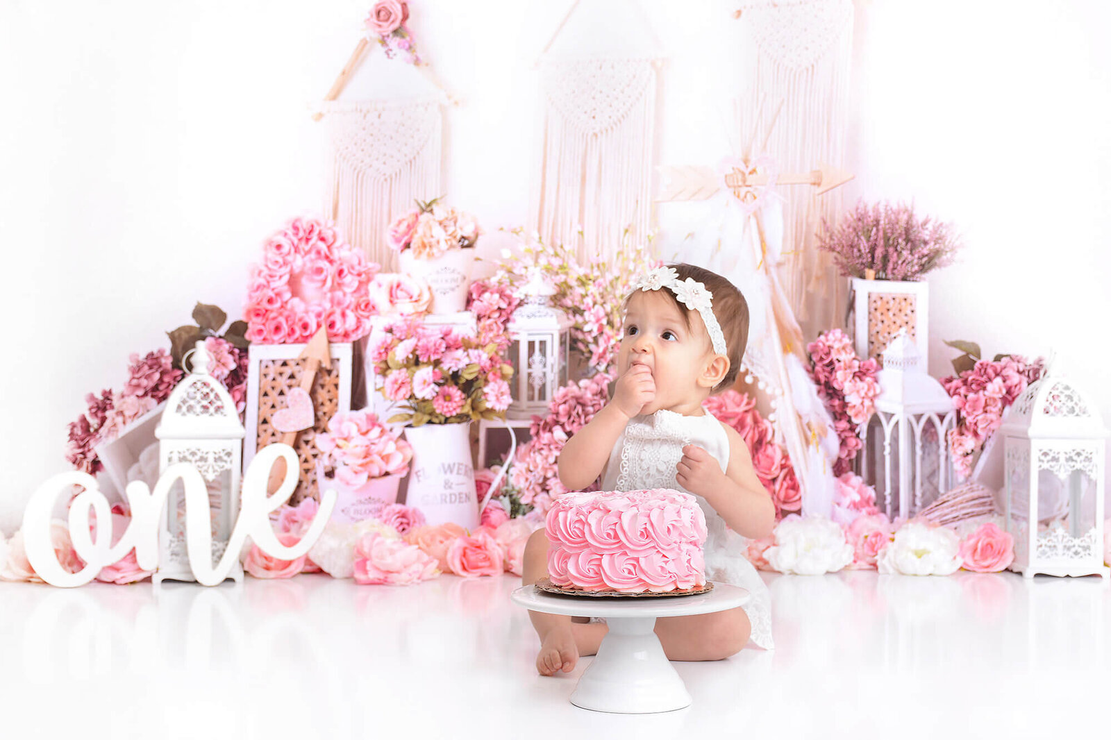 baby girl eats her birthday cake at her photoshoot