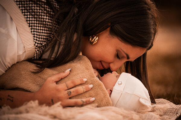 Een newborn fotoshoot in de natuur, omringt door de ouders en trouwe hond