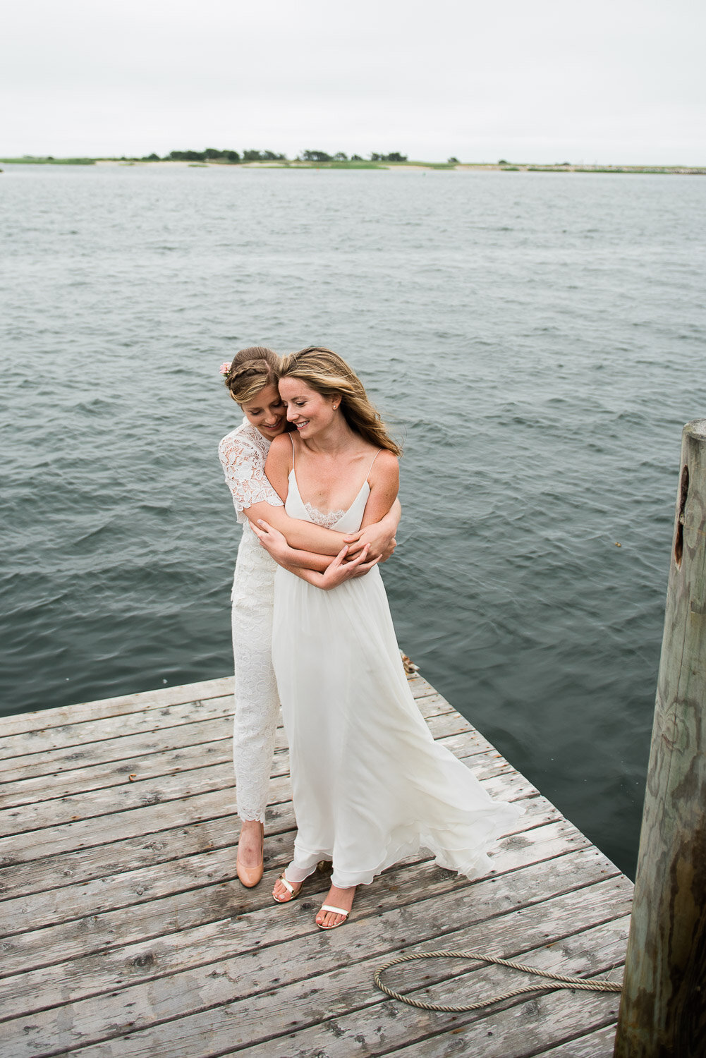 brides embrace on dock