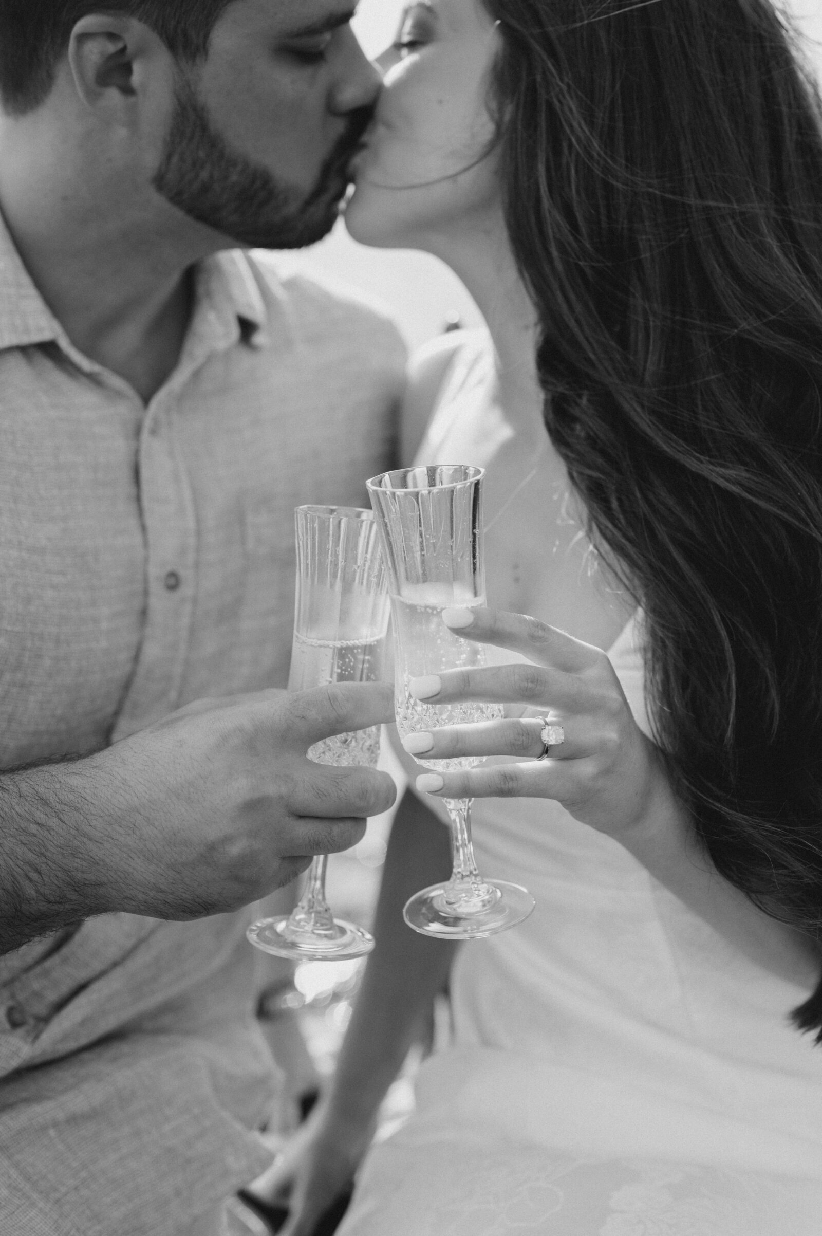 couple cheers champagne glasses on boat near Reynolds Lake Oconee