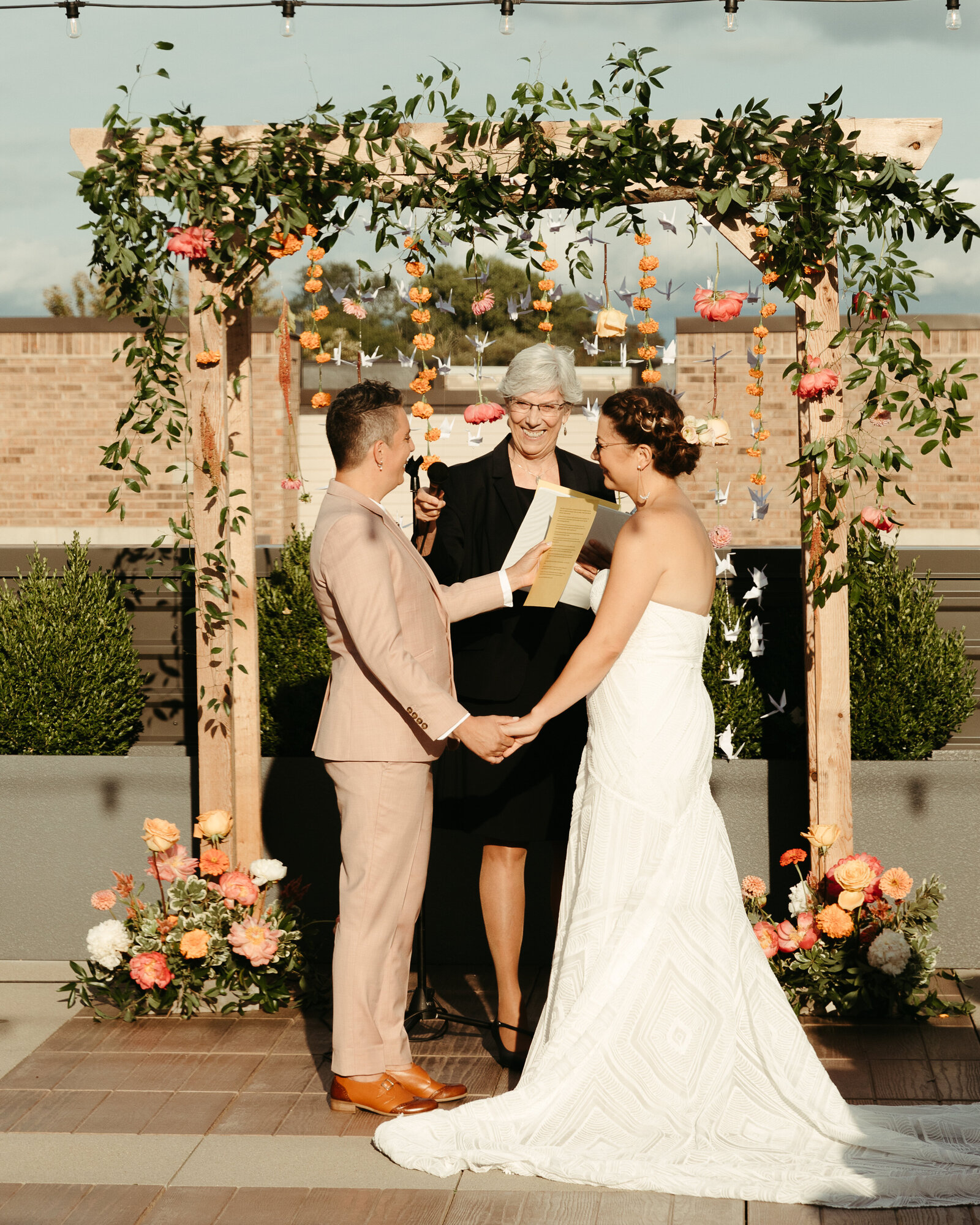 Brides getting married on a rooftop in front of an alter