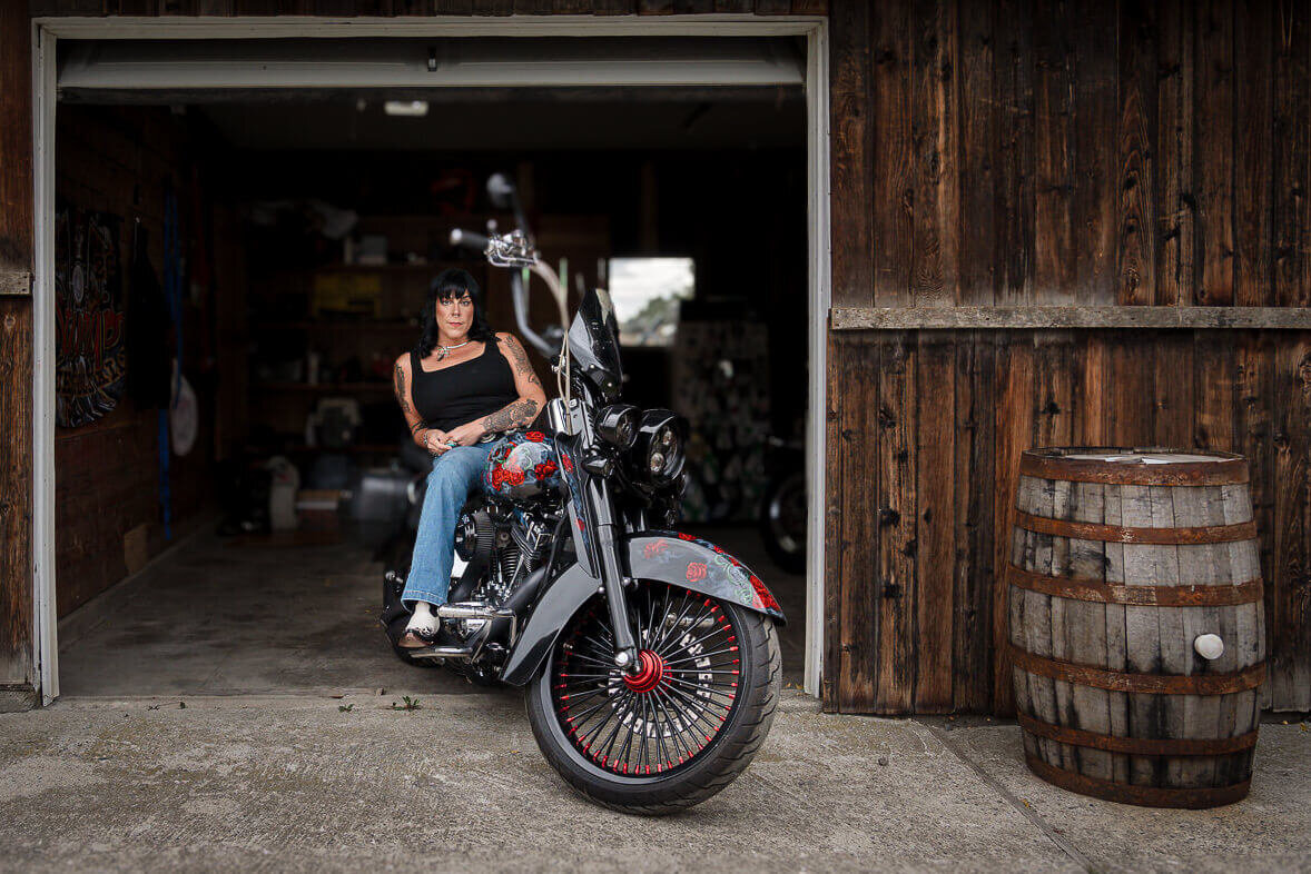 biker-woman-sitting-on-custom-motorcycle-in-garage