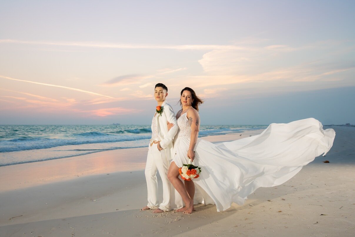 Brides holding hands on the beach at sunset after their Sarasota Wedding