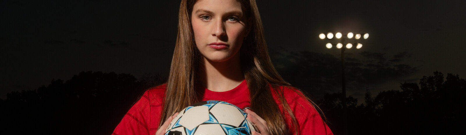 a high school soccer player poses for her senior photos