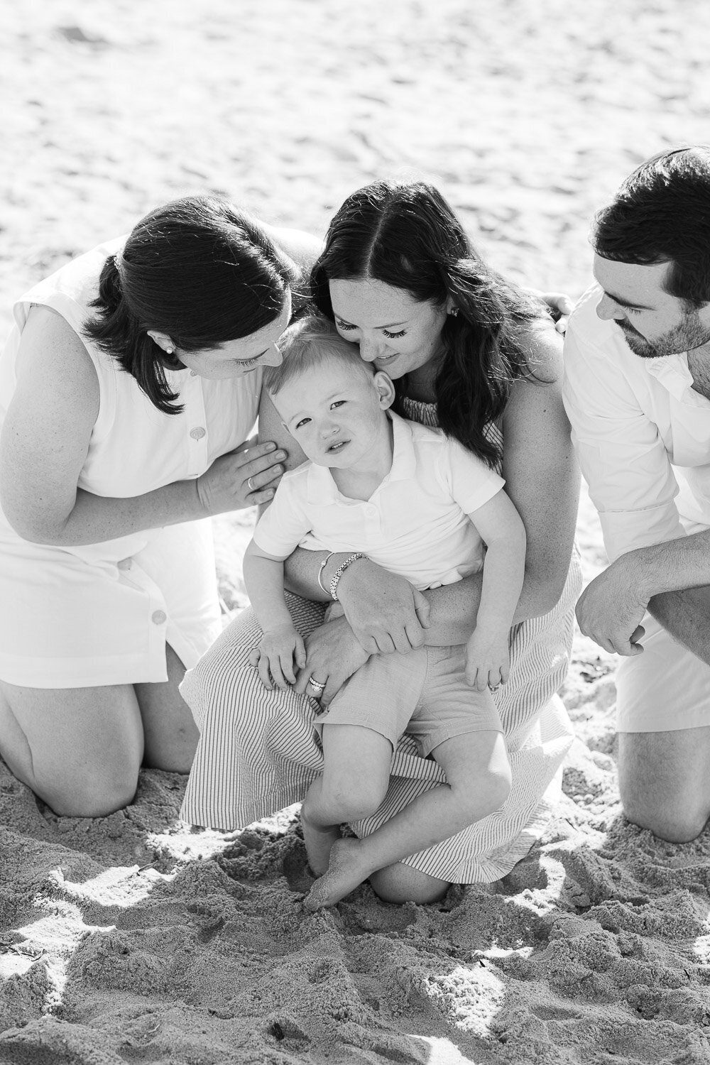 toddler boy being snuggled on beach