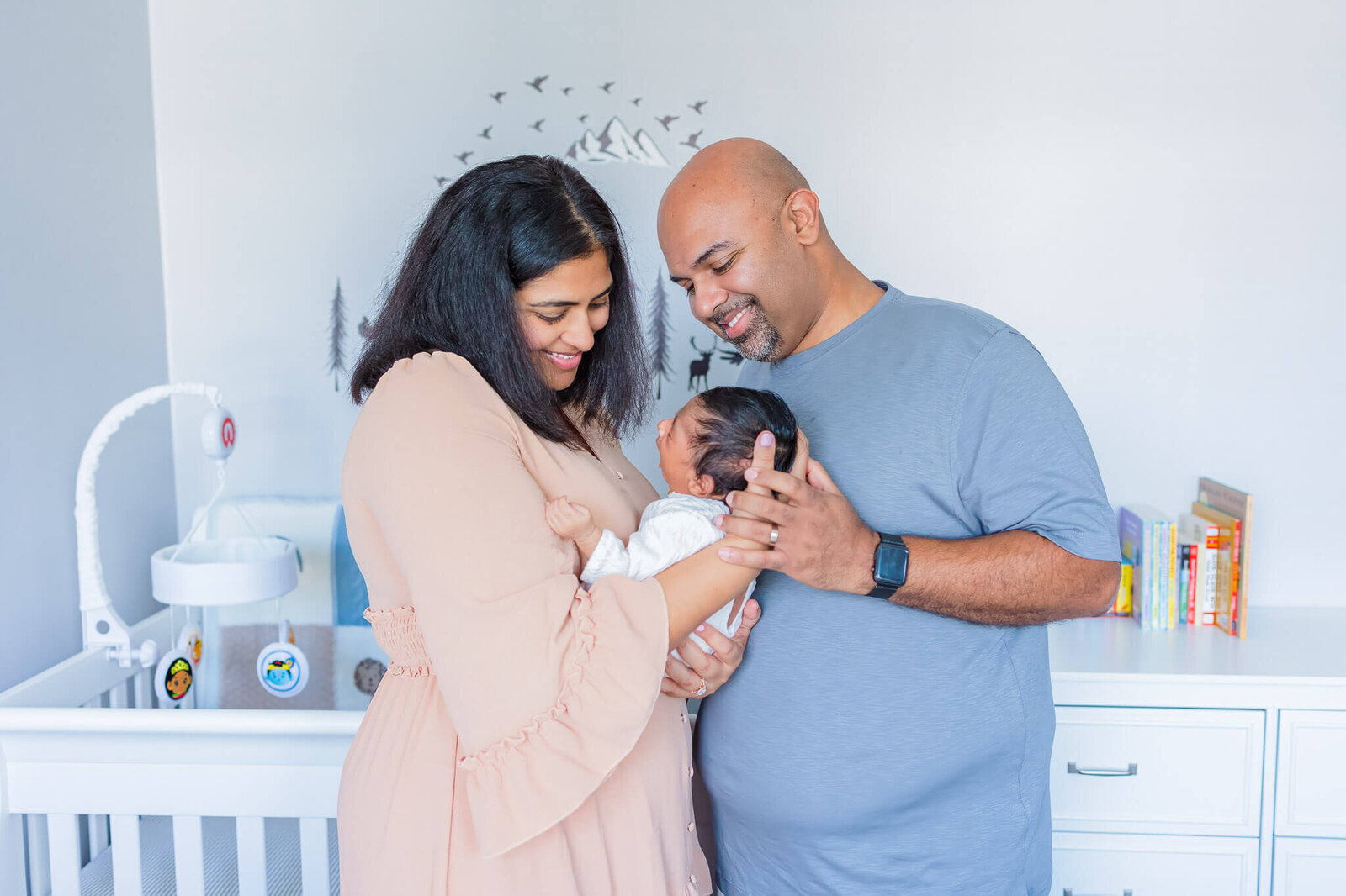 A mom and dad holding their newborn son in their Washington DC home.