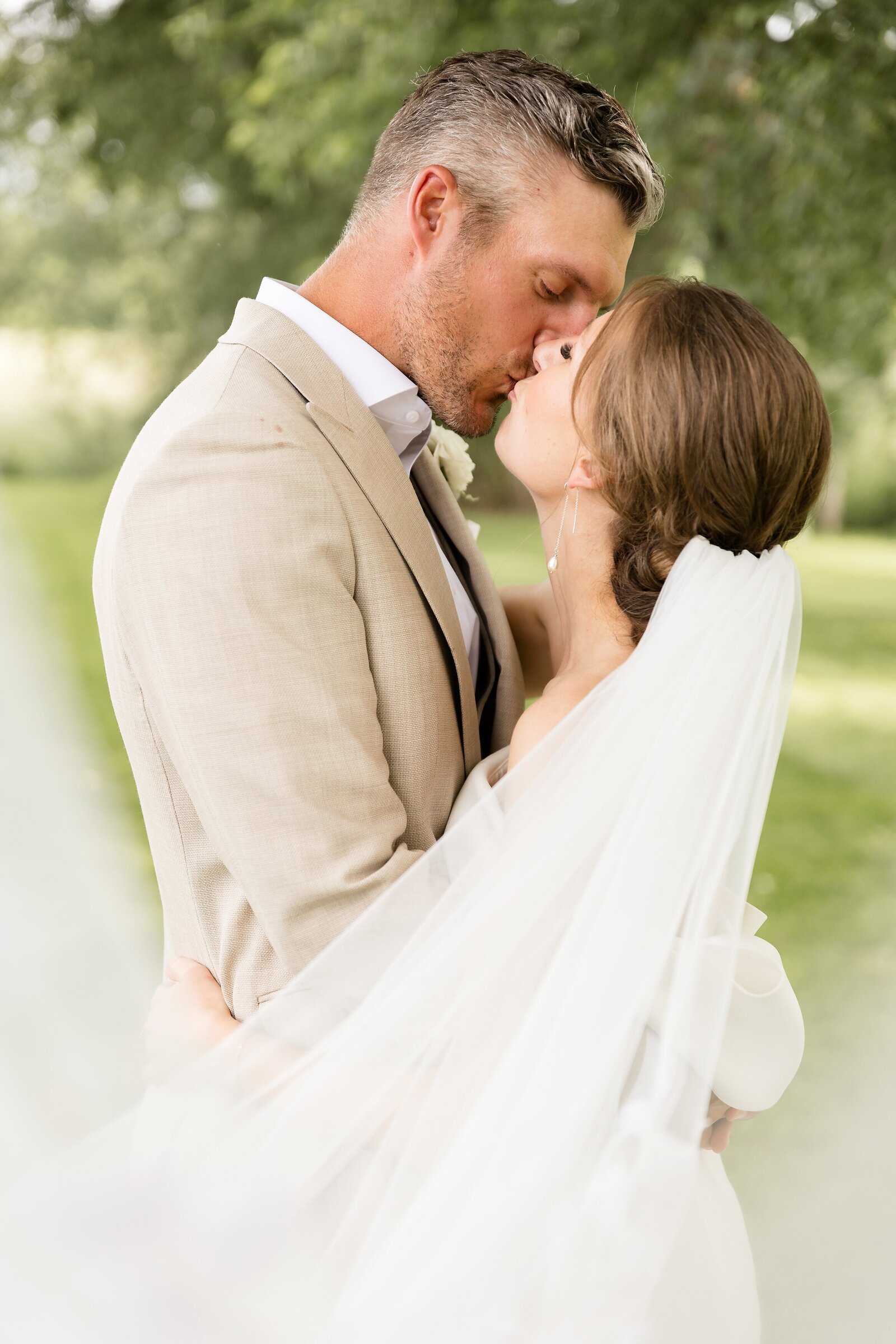 Wedding-couple-shares-a-sweet-kiss-as-the-veil-swoops-towards-camera-at-elle-by-stella
