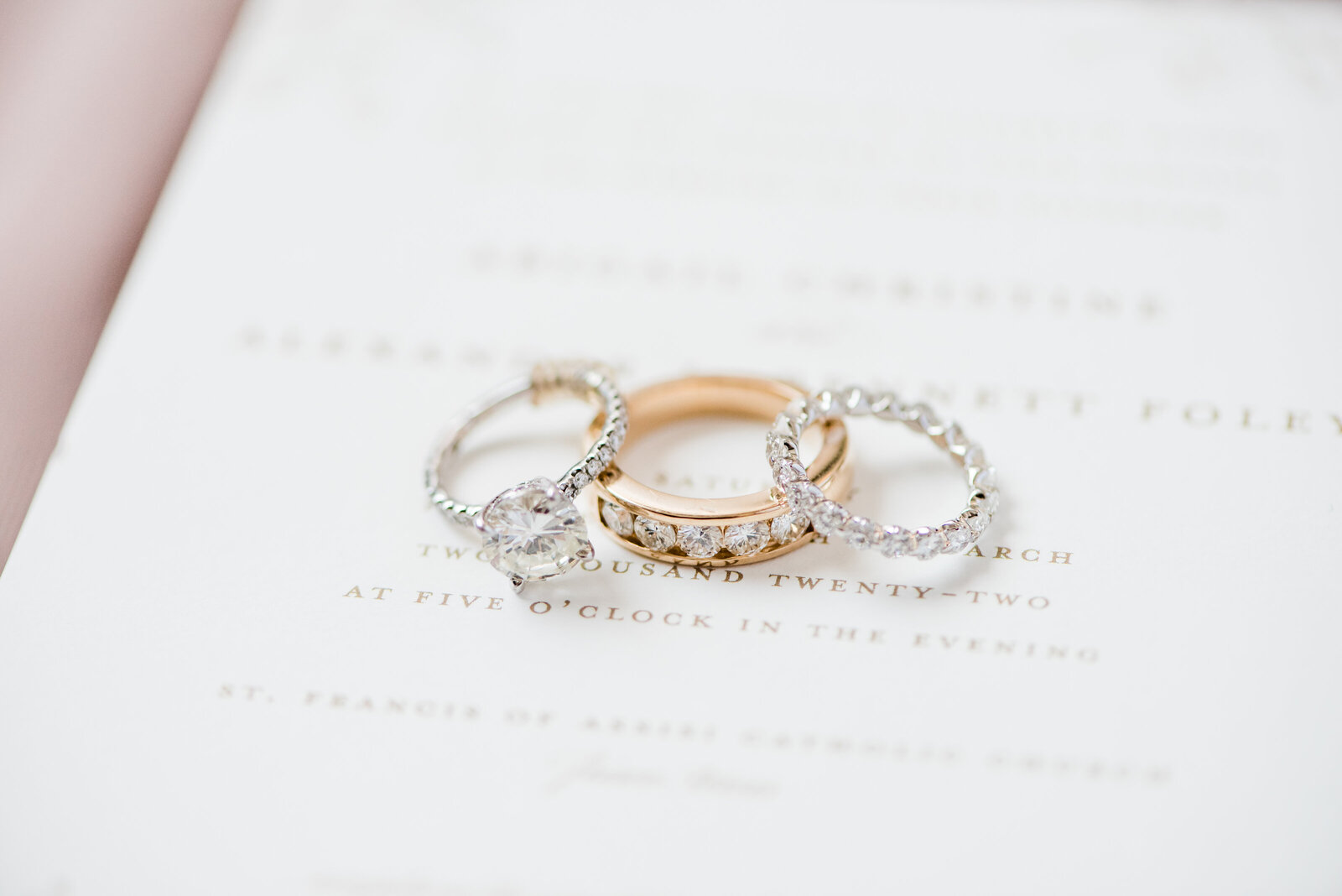 Wedding rings lay on wedding stationery
